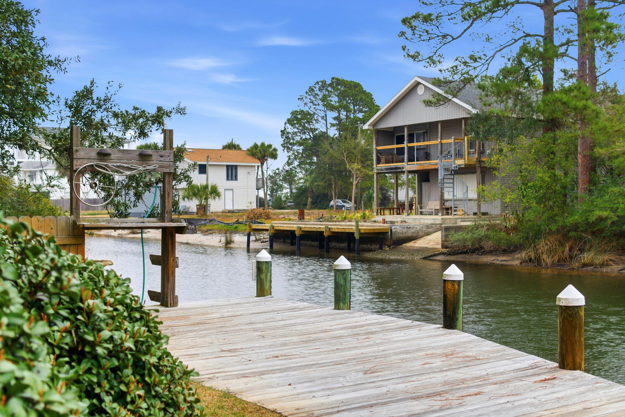 Enjoy the Gulf Breeze waterfront lifestyle in this all-brick, canal-front home offering deep water access with direct passage to Pensacola Bay. Perfect for boating enthusiasts, entertaining, or low-maintenance coastal living, this 3-bedroom, 2-bath residence delivers a well-designed layout & everyday livability in a true Florida setting. The open floor plan features a wood-burning fireplace with electric insert, trey ceilings with custom lighting, an updated kitchen with granite countertops & stainless steel appliances, and a bright, heated & cooled Florida room that enhances the living space year-round. Tile flows throughout the main living areas & bathrooms, while the bedrooms offer warm hardwood flooring. Both the primary bathroom features heated floors. The roof was replaced in 2023, HVAC installed in 2019 and water heater newly installed in 2024 providing the ultimate peace of mind. The primary bedroom is positioned just off the Florida room with direct views of the back deck & canal. Step outside to a backyard designed for relaxation & entertaining, complete with mature landscaping, a paved patio, hot tub (as-is), and an 8,000-lb boat lift. A power-equipped 10x12 cement board shed provides excellent space for storage, a workshop, or gardening, with an additional garden area along the side of the home adding charm. Whether you are seeking a full-time residence, second home, or potential investment opportunity, this canal-front home offers an ideal blend of waterfront access, thoughtful updates, & the Florida lifestyle you have been waiting for.