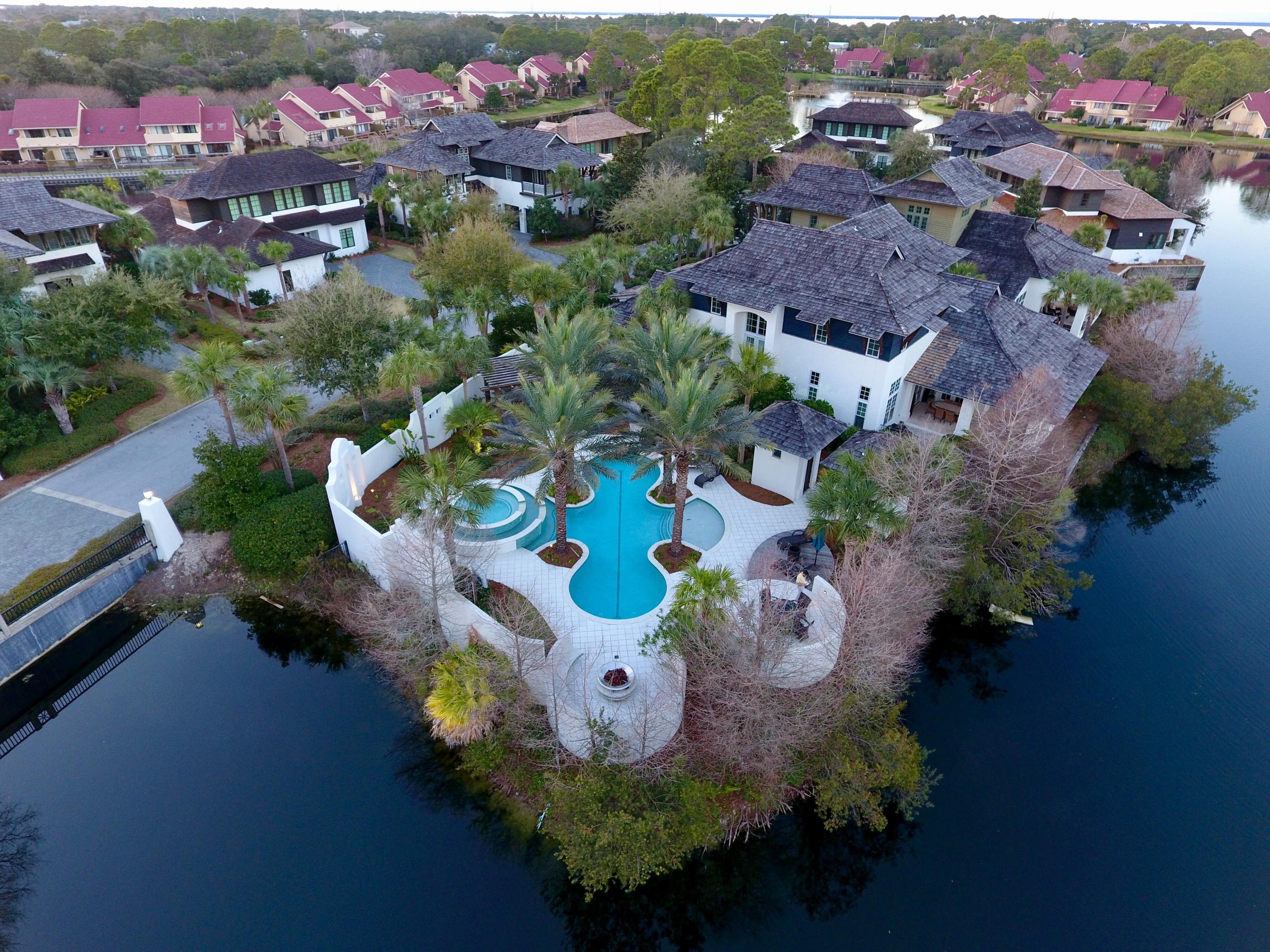 Once in a great while, a truly spectacular custom built home becomes available to purchase.
Gated luxury living in Sandestin. A work of art in form and functionality. Stunning West Indies vernacular designed home that epitomizes the Emerald Coast, living in a most serene resort style setting. This private retreat expands graciously to host large-scale entertaining in and around the unsurpassed heated lagoon pool, fire pit and large hot tub. Nestled onto a small peninsula of land by Horseshoe Lake. Home features four bedrooms, five full baths and one half bath. This stucco home is complete with hardwood siding, cedar shingles, Pella wood windows, cobblestone pavers, and mahogany front door. Step inside and be greeted to wood flooring, travertine, much more!