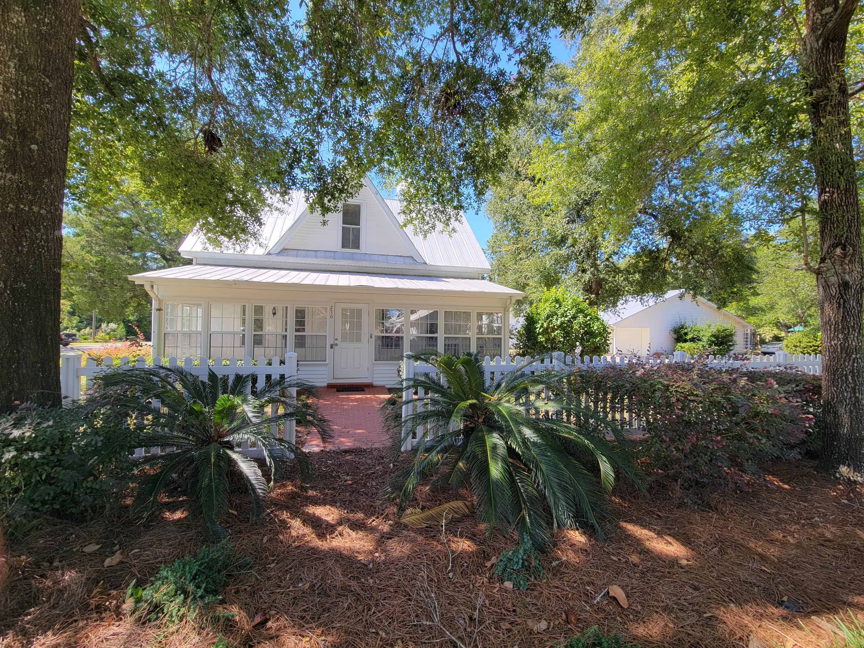 Welcome to the heart of DeFuniak Springs where history meets charm in this recently renovated historic home! Nestled on a picturesque oak-lined street, just steps away from the Historical Downtown and DeFuniak Lake yard. and Library.  Just imagine sipping coffee from any of the three porches on this  exquisite southern home.  Meticulously remodeled and lovingly cared for, this 3 bedrooms, 2 1/2 bath treasure was upgraded seamlessly blending vintage charm with modern comforts, yet  still providing the timeless allure of historic details.  Living area is appx. 2220 sf with a side glass sunporch 310 sf that could easily included into additional living area.  Two bedrooms and two  baths downstairs and 1 bedroom, and living room and 1/2 bath upstairs. CLICK ON 'MORE' AND 'DOCUMENT' TABS----- Super size kitchen with new granite counter tops and freshly painted cabinets.  All appliances included.  Continuous new floor covering throughout. Gorgeous new shiplap board ceiling in formal dining room, freshly painted ceilings and walls in bright white throughout. From the formal dining room allows so much light and room for gazing over the serene private backyard, promising endless possibilities for outdoor living and relaxation with 2 detached garages, one 1500 s.f. double car garage with concrete floor 20x30' with workshop and storage area complete with 1/2 bath and central air/heat.  It also has an attached carport 10x30' that is perfect to have cookouts and use for entertaining. The  2nd super-size garage, complete table top work station with concrete floor to accommodate a large size RV.  The backyard is like a retreat for family and friends with plenty of driveway space for parking and entertaining. Updated landscaping and sprinkler system with a 280' deep well into the aquafer with totally new pump and casing.  The Rhino Roofing still has 15 years on warranty.  All new window blinds are on order and will be installed upon arrival.   Improvements also includes 16 windows glass to be replaced. (on order).