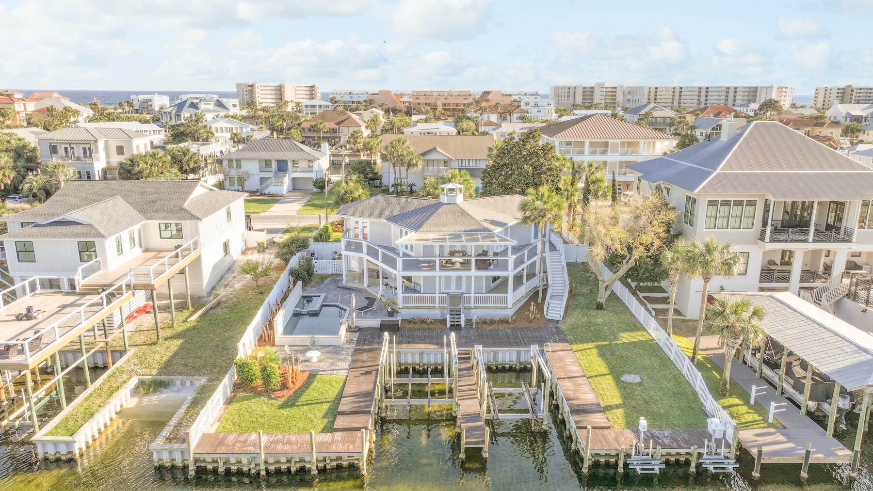 Waterfront luxury meets effortless coastal living--this is the Emerald Coast dream, fully realized. 90 feet of prime waterfront, private boat slips, jet ski lifts, a resort-style pool, and deeded beach access within a short bike or golf cart ride. This is where boating days, beach sunsets, and effortless entertaining become your everyday reality. Launch from your private dock and be at Crab Island or in the Gulf in under 10 minutes. Whether it's boating, fishing, or dock-to-dinner nights via water taxi, this location delivers the ultimate coastal lifestyle. Offered turnkey and fully furnished, this home is ready to generate income or unforgettable memories from day one.Start your mornings with coffee and sunrise views from expansive wraparound balconies. Spend your days entertaining by the heated pool and spa, grilling on the deck, or unwinding fireside while casting a line from your private dockFirst level features two large garages, a bedroom, full bath, laundry, and a massive bonus space perfect for a game room, bunk room, or office.
Second level showcases two spacious waterfront primary suites, each with private balcony access, en-suite baths, and walk-in closets
The heart of the home is a generous open-concept kitchen and living area centered around a cozy fireplace--ideal for gathering after a day on the water. Whether you're building your investment portfolio, searching for a second home, or ready for full-time coastal living,The only thing missing is you. Schedule your private viewing now and experience it firsthand.