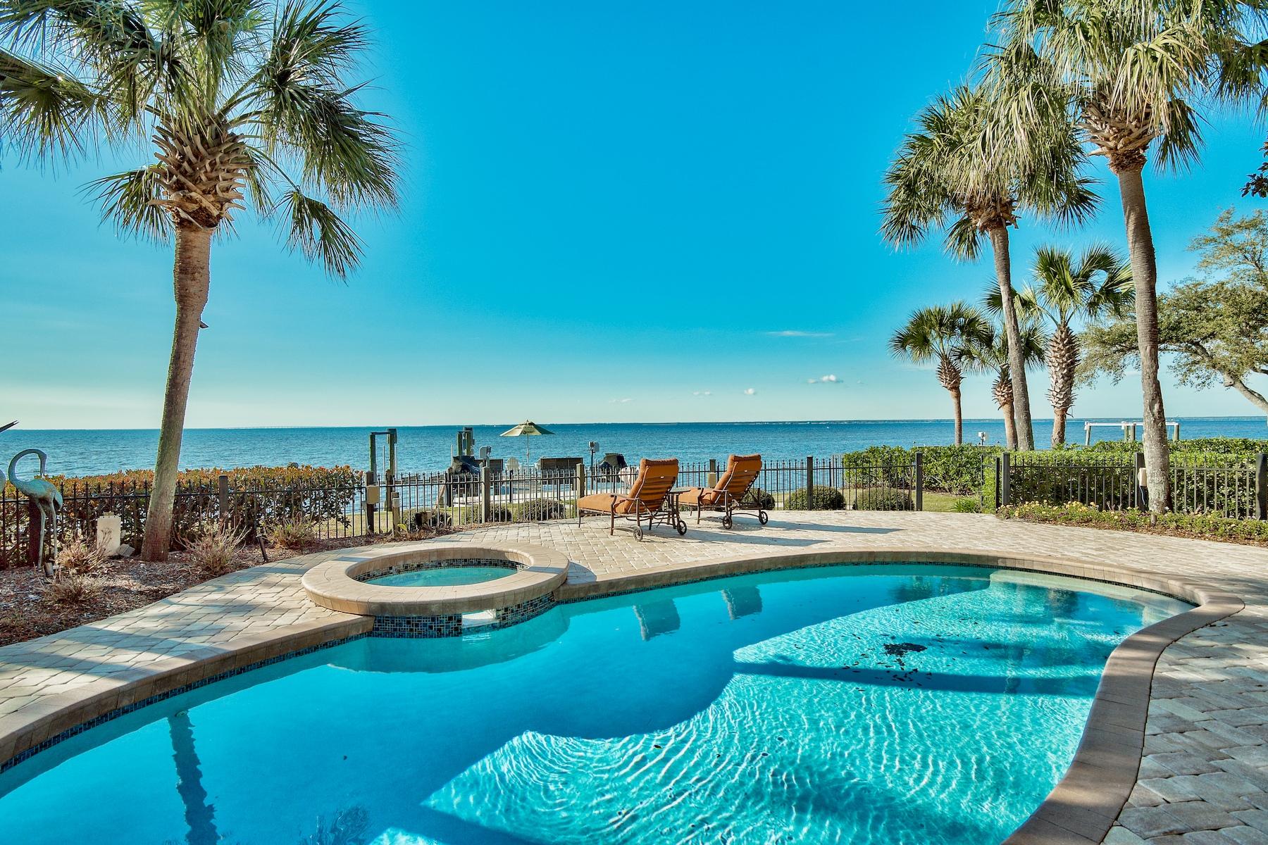 Bayfront Living with Pool, Dock and Wine Room. This 3 bedroom/4 bath 3,573 sq.ft. home in Burnt Pine is for those who desire waterfront living, stunning sunsets and a room for everything. Set on a peaceful wooded lot with pool and private dock, it offers more than a luxury home  it's a lifestyle.This bayfront home offers views all throughout the home. There are two nice size living areas offering options for an office, den, exercise area, etc. The breakfast room off the kitchen is the perfect way to start your day enjoying the breathe taking views of the morning sun. End your day gathering with family and friends around the well designed bar area equipped with refrigerator drawers and ice machine. The formal dining room provides an elegant area for entertaining beneath a glittering chandelier. Dual-aspect floor-to-ceiling windows showcase tranquil Choctawhatchee Bay views. The adjoining kitchen has mahogany cabinets which contrast beautifully with the ogre-edged granite counter tops and island prep space. 
Stone flooring, clerestory windows, trey ceilings with moldings and recessed lighting all set the scene for a luxury lifestyle for those appreciate fine attention to detail.  The master suite includes his and hers bathroom separated by a corner bathtub.  Beyond the outdoor kitchen and screened porch with retractable screens and through the fenced yard, a winding path leads through the paved pool area to the boat dock. This is the place for relaxing and enjoying infinite views to the horizon. Plenty of room for your boat, jet ski (on lifts) or standup paddle boards when the mood strikes. All this plus golf, tennis and beach amenities within the Sandestin Golf and Beach Resort