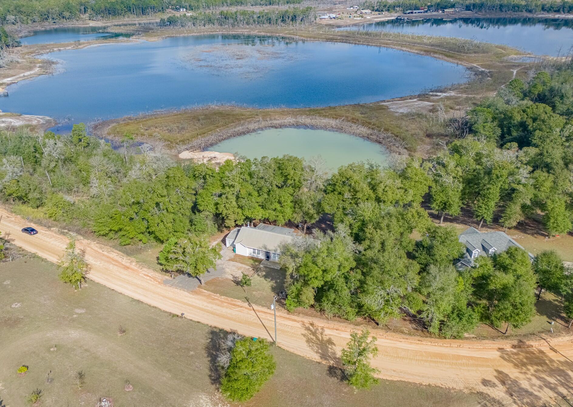 Experience serene waterfront living in this beautifully appointed 3-bedroom, 2-bath residence overlooking the peaceful waters of Upper Spring Pond. Perfectly blending the charm of country living with the convenience of nearby amenities, this home offers close proximity to beaches, shopping, dining, and the airport. The inviting open-concept living area features a cozy wood-burning fireplace and expansive sliding glass doors that frame stunning lake views and fill the home with natural light. The spacious kitchen is thoughtfully designed with a picturesque window overlooking the water, creating a seamless connection between indoor comfort and the surrounding natural beauty. Generously sized bedrooms provide ample space for relaxation, while the outdoor living areas truly set this property apart. Enjoy mature oak trees, an expansive back deck, and a charming porch swing ideal for morning coffee or evening sunsets. The backyard offers endless opportunities for outdoor enjoyment, from bonfires and gatherings to swimming, kayaking, or fishing right from your own shoreline. This private waterfront retreat offers space, tranquility, and a lifestyle you'll love. Properties like this are rare schedule your private showing today and make lakefront living your reality.