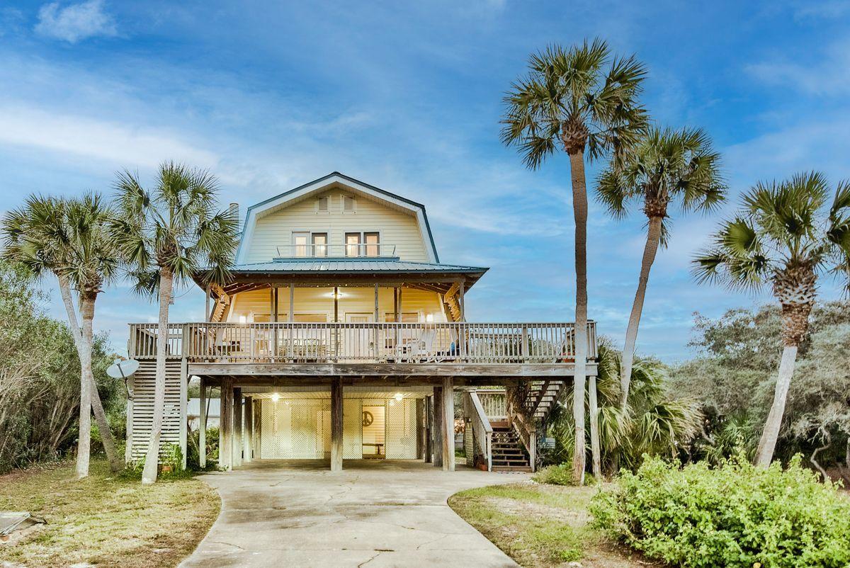 This highly coveted second-tier location in Old Blue Mountain Beach nestles a charming vintage beach cottage boasting heart pine floors and a cozy fireplace.  A generous quarter acre homesite offers future build-out potential as well as up to Walton County's height restriction of 50'.  Some renovation on bathrooms has been completed.  Great Gulf views across road.  Beach access is three lots over to either side. Old Blue Mountain neighborhood owners have BEACH USE rights, not just beach access, a rare amenity in neighborhoods along 30A!   Also, there is a mechanical lift from the carport to the second floor!  Stroll to restaurants, cafes, bakery & grocery or jump on your bike and hit the bike path.
