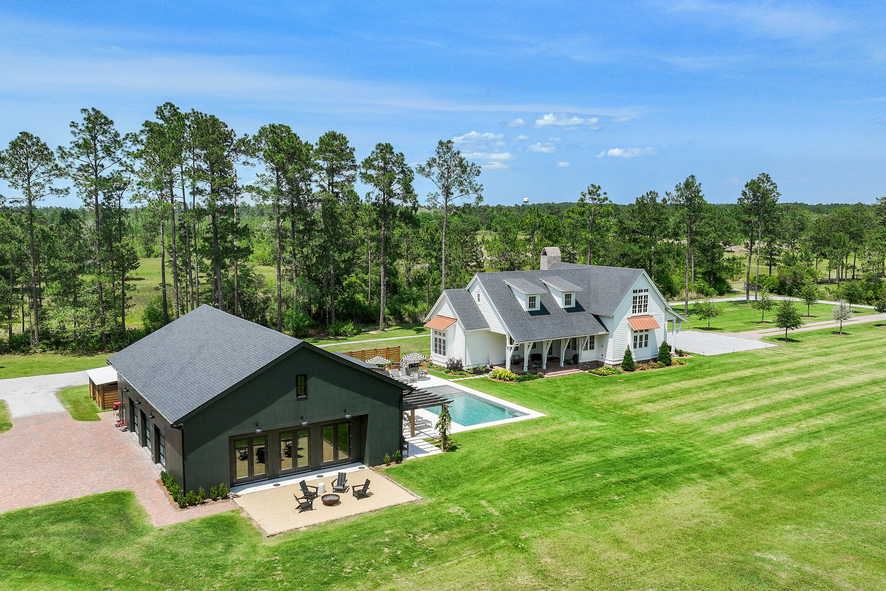 A Truly Rare and Unmatched Opportunity in Freeport, FL. For those dreaming of being close to the beach—yet far from the crowds—this extraordinary 5-acre estate offers the perfect blend of privacy, space, and future potential. Nestled just 5 miles east of Hwy 331 on scenic Hwy 20, this beautifully crafted homestead is a one-of-a-kind retreat in the heart of fast-growing Freeport. Subdivided into four platted 2.5-acre lots, this estate also features 2 additional lots for sale if you're looking to expand for your kids to have houses next door, build additional homes to sell on individual parcels, or simply enjoy the privacy and acreage all to yourself. With approximately 8 acres cleared, a picturesque pond, and a tree-lined entrance, this land is as usable as it.. is stunning. The 3,382 sq ft custom-built main residence is a showpiece, featuring 4 bedrooms, 4.5 bathrooms, wide-plank white oak floors, shiplap walls, Sierra Pacific windows/doors with white oak interiors, and two oversized porches overlooking serene pasture views. The open-concept kitchen, living, and dining areas include a breakfast nook and a spacious butler's pantrydesigned for everyday comfort and elegant entertaining. Step outside to find a 16'x32' resort-style pool with shellstone decking, raised garden beds, a fire pit, and ample room for play, relaxation, or gatherings. This is the kind of place where memories are made. A 2,581 sq ft fully climate-controlled 40'x60' detached garage/workshop offers serious bonus space with a 12'x24' guest suite and full bath, ninja-coated floors, retractable batting cage, workout zone, storage mezzanine, and Sonos sound systemideal for hobbies, hosting, or multi-generational living. Plus, a separate 36'x48' metal pole barn provides plenty of storage for equipment, boats, or recreational gear. Surrounded by upscale equestrian properties and family homesteads, this property supports a lifestyle of gardening, livestock, recreation, or just peace and quietall with no HOA and only minutes to Freeport amenities and the white-sand beaches of South Walton. Whether you're looking for a legacy property, a private family compound, or a unique investment with room to growthis is the one that rarely comes along.