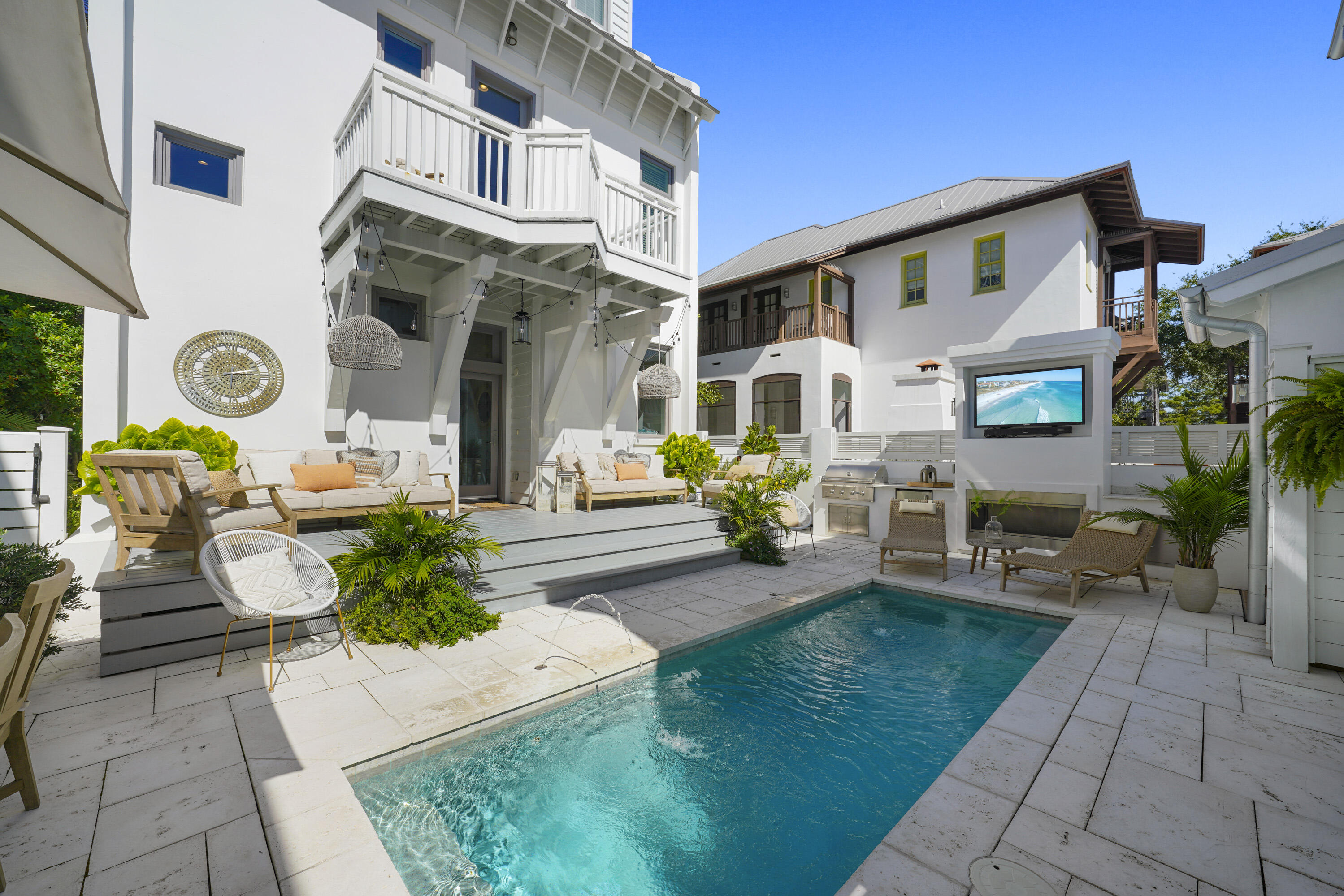This immaculate, never rented Rosemary Beach home was fully renovated and re-designed and is a must-see. During the renovation of the main house a brand new heated pool and carriage house featuring 2 bedrooms and 2 car garage were added. In total this home features 5 spacious bedrooms each with their own private baths and balconies plus a bunk room that sleeps 4. The open-concept first floor is ideal for entertaining, with a gourmet kitchen boasting commercial-grade Viking appliances, a massive quartz island, farmhouse sink, and sleek floating shelves. The fireside family room and dining area, complete with a wet bar, ice maker, and beverage center, make hosting a breeze. Gorgeous wide-plank hardwood floors flow throughout, and a large laundry/mudroom and powder room are conveniently located just off the main living space. Step outside to a private oasis with a heated pool, outdoor fireplace, and a fully equipped summer kitchen. The separate carriage house, built in 2019, offers additional accommodations with one bedroom and a bunk room. This property offers gorgeous views of East Kingston Park featuring fountains, serene landscapes, and established foliage- a picturesque hidden park right off your own front porch.