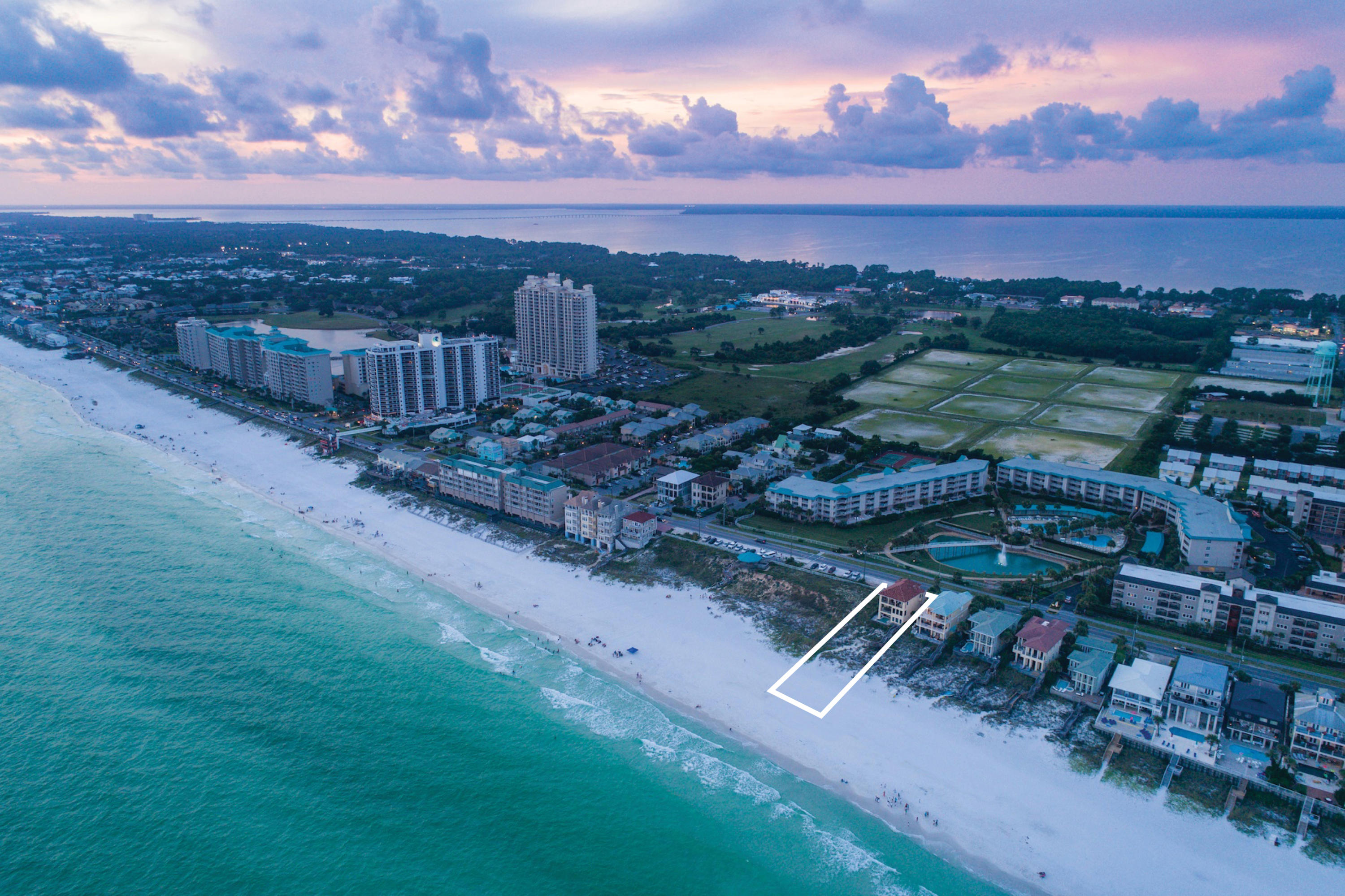 Pristine gulf views framed by floor to ceiling glass define this majestic beachfront retreat prominently situated over 30' above sea level with an unparalleled southwestern orientation yielding endless gulf vistas from each level of this masterful home. This impressive rental machine boasts five full bedroom suites and has been completely remodeled with finely appointed coastal contemporary finishes thoughtfully implemented for optimal rental opportunity and ultimate longevity including the coveted addition of a private gulf pool area. Notable features include an impressive three story vertical footprint accessible by private elevator with a spacious open floor plan designed for legacy living with concrete block and stucco veneer. The first level offers a large two car garage and is thoughtfully designed as a private guest quarters complete with an oversized gulf front living room and kitchen as well as a spacious gulf front master bedroom and ensuite offering immediate access to the covered gulf front pool area and private beach walkover. Outstanding gulf front views abound from the extremely open second level yielding exceptional southern and western exposures as this home has been built further seaward than the neighboring property. The pristine chef's kitchen is anchored by a massive center island custom designed with a quartz waterfall slab as well as beautiful custom cabinetry and stainless appliances offering a sleek aesthetic created to compliment the prominent views over the emerald green waters of the Gulf of Mexico. The open kitchen offers immediate access to the living and dining areas characterized by artful trim and wood work including chevron ship lap accents and white washed pecky cypress ceilings. The second level also offers a guest suite with ensuite bathroom. The master level occupies the entire southern elevation on the third floor and is truly oversized complete with a private sitting area overlooking prime beach frontage as well as a private wetbar and spa-like ensuite bathroom featuring dual vanities, walk in shower, walk in closets and a soaking tub. There is a junior master that also enjoys unobstructed gulf views located on the northern elevation of the third level and yields a spacious sitting area and full bathroom. Other notable features include covered porches on each level of the home as well as ample parking out front. This prime spot on scenic 98 marks one of the highest elevations above sea level. This home is primely located in a central location within the Destin/Miramar Beach corridor offering exceptional proximity to world class dining, shopping and golfing as well as the Sandestin Outlet Mall and adjoining resort.