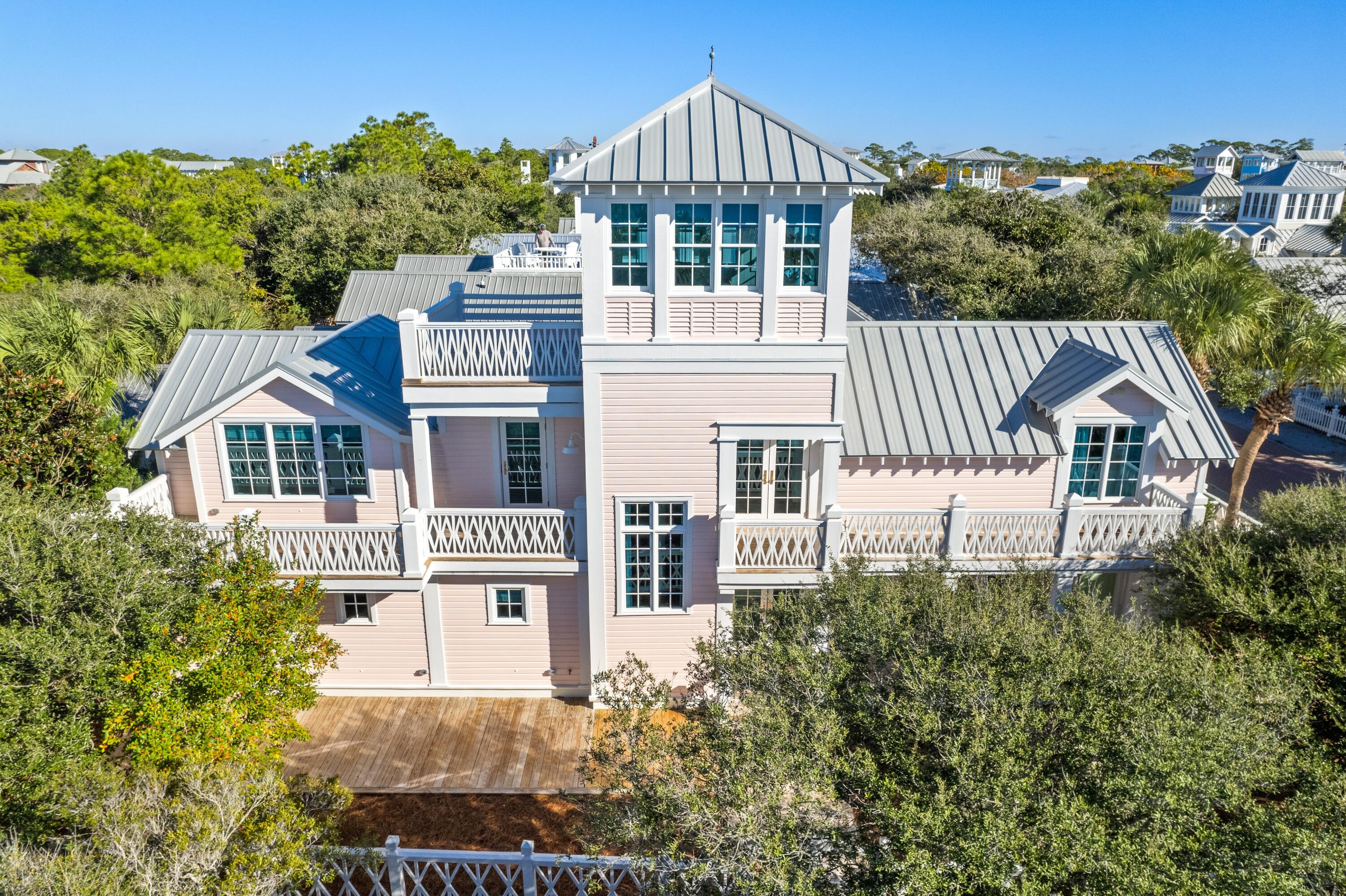 Welcome to your dream beach home, a meticulously renovated five-bedroom, five-bathroom sanctuary in Seaside, Florida. This exceptional property seamlessly blends modern luxury with timeless coastal charm, offering an unparalleled living experience. This home has been thoughtfully renovated inside and out, ensuring every detail meets the highest standards of quality and design. Seldom does a home this perfect and in a prime location become available in Seaside. The interior wood walls and ceiling are painted a crisp white throughout the home.  The master suite, with walk-in closet, plus three additional bedrooms, each with a private bath, can be found on the first level. The master bath features double sinks, quartz countertops, and marble tile. The laundry room is also on the first level and has plenty of storage, an ice maker, and refrigerated drawers for beverages. The second level has the ever-popular open floor plan. The kitchen flows seamlessly into the dining area and into the beautiful, light filled living room.  A unique ceiling design in the living room defines this special space. The spacious galley kitchen includes a 11' quartz breakfast bar, custom made cabinetry and high-end appliances. Off the kitchen is a wet bar with ice maker, refrigerated drawers and a pantry. The fifth bedroom, currently furnished as a media room and a full bath are also on the second level. Framing the second floor on the south side are two decks accessed via the living area and from the kitchen. The jewel in the crown of this lovely home is to ascend the steps to the third level enclosed tower and open sundeck to take in breathtaking gulf and sunset views from this spectacular perch. In addition to the sun deck, enjoy multiple outdoor spaces, ideal for alfresco dining and relaxation. The stunning interior furnishings were carefully selected to enhance the elegant décor of every room. Experience immersive audio throughout the home with a surround sound system, ideal for entertaining or relaxing with your favorite music.  Located just a short stroll from Seaside's renowned beaches, boutique shopping, and gourmet dining, this home offers the quintessential coastal lifestyle. Don't miss the opportunity to own this exceptional property in one of Florida's most desirable communities.