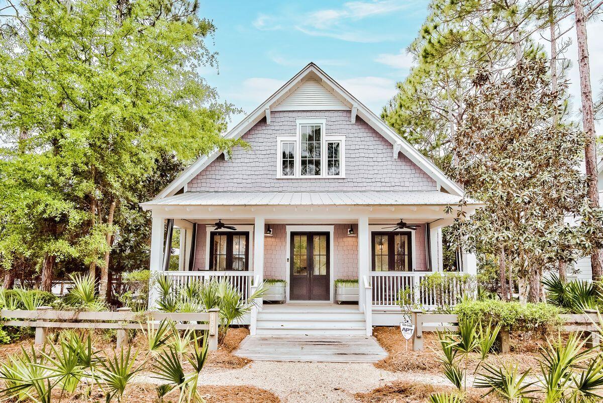 This attractive custom beach cottage has many surprises with its extensive floor plan and private pool on one of the largest lots in WaterColor. Carrara marble counters throughout, low-maintenance ipe decking, a Rinnai tankless water heater, and a central vacuum make luxury living easy. The full-width front porch provides a charming space to sit out on rockers with an icy drink or a good novel. Double doors lead into the airy open living space with volume ceiling and whitewashed walls from a nature-inspired palette. A stone fireplace provides a focal point for relaxing on sofas and watching TV. The formal dining area is perfect for entertaining, enhanced by the wine refrigerator for serving perfectly chilled drinks and aperitifs. The adjoining gourmet kitchen boasts full-height white gloss cabinets, a full range of appliances and an attractive glass tile backsplash. The island breakfast bar is the perfect place for serving snacks, drinks and canapes before dinner. The whitewashed flooring extends into the first-floor bedrooms with wainscoting, a dressing room and a garden tub in the master en suite. Stairs lead to a mezzanine media room/den with a second generously sized master suite. Check out the cushioned window seat, enviable walk-in closet and generous storage. The huge marble ensuite includes a twin vanity, walk-in shower and a roll-edge tub. Glazed doors on the first floor open onto the screened porch with swing seat. It provides easy access to the park-sized fenced yard with pool, water feature and paved terrace. Backing onto a preserve, it's a shady space for listening to the breeze blow gently through the mature trees. A covered pergola leads to another surprise  a self-contained carriage house. Situated above the two-car garage, this luxury guest suite is complete with kitchenette, bedroom and en suite bathroom. The WaterColor community is known for its excellent amenities including a beach club, tennis center, boathouse, playground, wooded trails and parks and multiple community pools in addition to the lazy river at Camp Watercolor. The sale includes beautiful furnishings, making this an ideal second home or full-time residence.