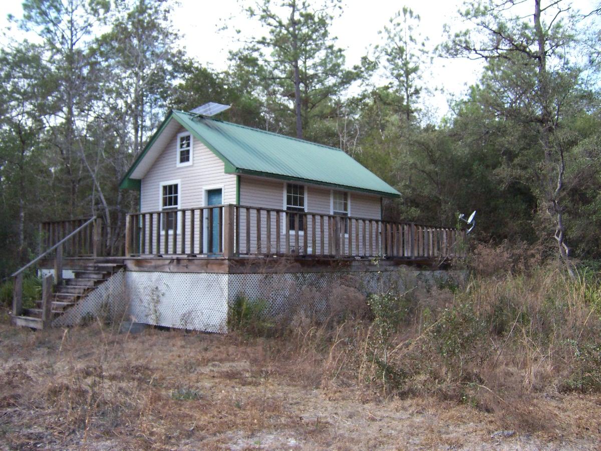 Hunters Paradise on aprox 13 acres! There is an older block home that is built into the hill and a nice storage building in the woods across a private bridge over the creek. Tons of potential. The block home is 1 bedroom and one bath. It has all utilities run to it, but needs some work. There is a nice newer pole barn, an old root cellar, 2 small natural spring fed ponds, a large flowing creek with a private bridge across it and a newer storage building that has a metal roof, large deck and vinyl siding and a solar panel. It does not have any utilities. Property will probably not qualify for standard bank financing. Tons of potential. Perfect hunting camp with trails throughout. Wildlife everywhere. Very private remote setting.