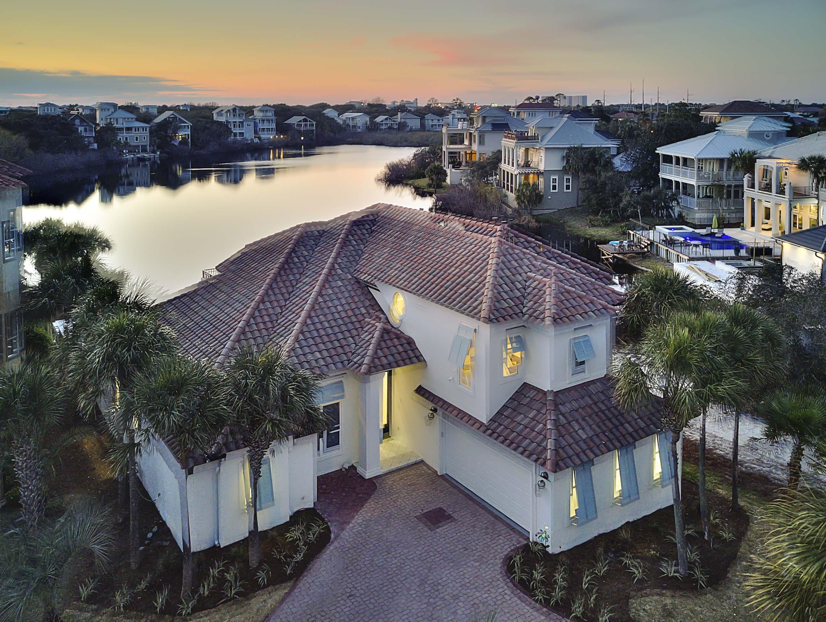 This casual coastal contemporary home seamlessly blends serenity and elegance into this beach-side lake front residence. It's perfectly situated two tiers off the Gulf of Mexico in the gated community of Destiny. In 2018, this home received a complete transformation by Coastline Luxury Homes with professional interior design & tastefully appointed furnishings. This home features 5 bedrooms, plus a bunk room, 4 full bathrooms and a large open floor plan with clean lines and pristine lake vistas. This lake front retreat is ideal for large families or an exemplary investment opportunity with over $200,000 in projected gross annual rental income for 2019..... Upon entering the foyer, you are immediately welcomed into the home by a wall of floor-to-ceiling windows that span the South elevation allowing an abundance of natural light to cascade into the main living area framing the west facing elevation defined by serene lake frontage and spectacular sunsets. The professionally designed kitchen is outfitted with floor to ceiling custom shaker cabinetry, stainless steel appliances including a professional grade gas cooktop, Bosch dual convection ovens and wine cooler. The kitchen pairs utility with exceptional beauty including quartz countertops, an ample sized island with an under-mount sink as well as ample storage in the separate pantry space. The covered rear patio is perfect for entertaining and features both covered and uncovered living space all of which is focused on the outdoor patio and in-ground pool area which opens to the expansive lake views. The first floor Master suite occupies it's own private wing and boasts an elegant decor, with beautiful views over the pool & lake. The owner's suite includes a large walk-in closet with built in shelving as well as a spa like Master bath complete with dual vanities, private water closet, free-standing soaking tub and large walk-in shower featuring a suspended glass surround, pebble flooring as well as floor to ceiling tiled accent walls. Other notable features of this property include: custom designer lighting, ship lap accents throughout, security system with multiple surveillance zones, custom window treatments including electronic window shades & plantation shutters as well as an ample size two-car garage. This home is the ideal property as it is fully transitional & highly functional as both a primary or secondary home as well as a top producing luxury vacation rental. This property is in close proximity to beach access as well as the exclusive amenities offered in Destiny which include a private fitness facility, community clubhouse, large community pool & spa, professional tennis courts and proximity to world class shopping, dining and entertainment. Schedule your private tour today.