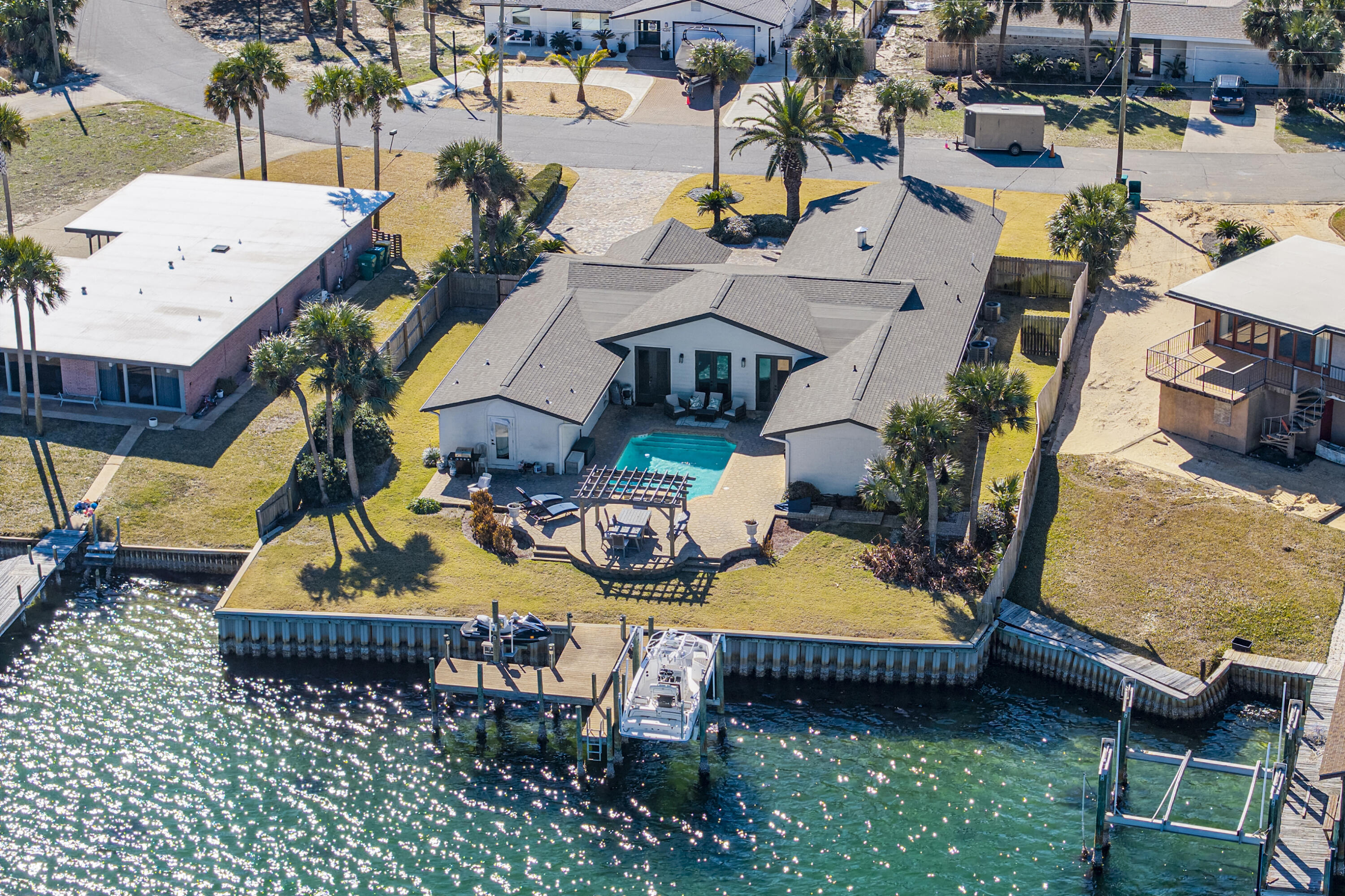 Stunning Newly Renovated Waterfront Coastal Retreat, Just Moments from the Beach!  Welcome to your slice of paradise, a beautifully reimagined 5-bed/4-full bath, single-family home spanning over 3200sf of sophisticated living space on a .32-acre lot with 100' waterfront in the highly desirable Okaloosa Island area.  This 1971 built home has been completely transformed with high-end renovations throughout, blending timeless coastal charm with contemporary luxury. Step inside to discover an open-concept floor plan bathed in natural light, featuring brand-new large format porcelain tile flooring, fresh neutral paint, smooth modern ceilings and trim, and elegant recessed lighting that creates an inviting, airy atmosphere perfect for relaxed Florida living or entertaining.  The gourmet kitchen is a chef's dream, boasting quartz countertops, matching solid quartz backsplash, stainless steel appliances, a large waterfall center island with breakfast bar seating, custom soft-close cabinetry, ideal for preparing meals while staying connected to family and guests in the adjoining living and dining areas.
The Waterfront Dining Room is perfect for entertaining. This space boasts the ability to seat 30 guests at one time, with a custom-made natural wood dining table. The wet bar sits on one side of the room with antique glass backsplash, an icemaker, and large wine cooler, while the adjacent side has a custom banquet booth for additional seating.  All 5 generous bedrooms offer ample space and comfort with access to the pool from every bedroom. The primary suite provides a peaceful retreat complete with a spa-like en-suite bathroom featuring modern fixtures, a walk-in shower, luxurious soaking tub, dual vanities, and plenty of storage. A newly built guest suite with its own private bathroom. Two bedrooms that share newly renovated jack and jill bathroom have been fully updated with contemporary tile work, new vanities, and high-efficiency fixtures.  Additional highlights include:
·Brand-new roof, HVAC system, plumbing, and electrical updates for peace of mind.  ·Brand new extra deep Double Car Garage for two large cars and more storage.  ·Expansive living areas with flexible bonus spaces (perfect for a home office, media room, or guest suite potential).  ·Large, fenced backyard with a pool, and outdoor teak dining and lounging areas for endless coastal entertaining.  ·Ample parking and storage options.  ·No HOA restrictions in this sought-after neighborhood.  Location is everything here - you're just a short 3 min stroll (500 ft.) from the sugar-white sands and emerald waters of the Gulf of Mexico. Enjoy full Choctawhatchee Bay access with a deep-water dock with both boat & wave runner lifts. Just out the backdoor you will have access to the Florida Intercoastal Waterway, Crab Island and the Gulf of Mexico, for fishing, water sports, and the vibrant dining/shopping scene of Fort Walton Beach and Destin. This prime spot offers the best of Emerald Coast living; beach proximity without the high-rise condo fees!  Whether you're seeking a primary residence, vacation getaway, or smart investment property in one of Florida's most coveted coastal markets, this turnkey renovated beauty is move-in ready and waiting for its new owners.  Don't miss this rare opportunity - schedule your private showing today and start living the beach life you've always dreamed of!