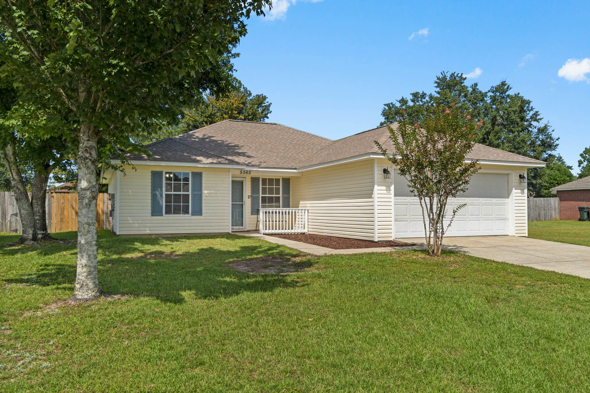 Welcome home to this adorable Florida cottage located on a sprawling 0.44 acre corner lot in Plantation Woods (with no HOA!). Featuring 3 beds and 2 baths, this home will charm you as soon as you pull up in the driveway and you'll love the fact that the roof was just replaced in August 2022 and the water heater and HVAC were replaced in 2020! Walk past the cozy covered front porch and enter inside where you'll find vaulted ceilings in the perfectly sized living room and lovely laminate flooring throughout (tile is in the wet areas and there is no carpet in this home!). The kitchen features recently updated stainless steel appliances, plenty of counter space, a separate pantry, and window overlooking the large backyard, and an eat in kitchen space. This split floor plan allows for owner's bedroom privacy with a large walk in closet and a spacious master bedroom. The other two bedrooms are nicely sized with a shared bathroom between them. The interior laundry room also has plenty of room and it leads to the two car garage. Walk out the brand back sliding glass door to the outside which is a dream with a massive fenced in backyard, a covered back patio, and a large storage building. There is a double gate that allows plenty of room to pull in a boat and/or RV for storage! Don't delay on making this perfect Milton retreat your new home!