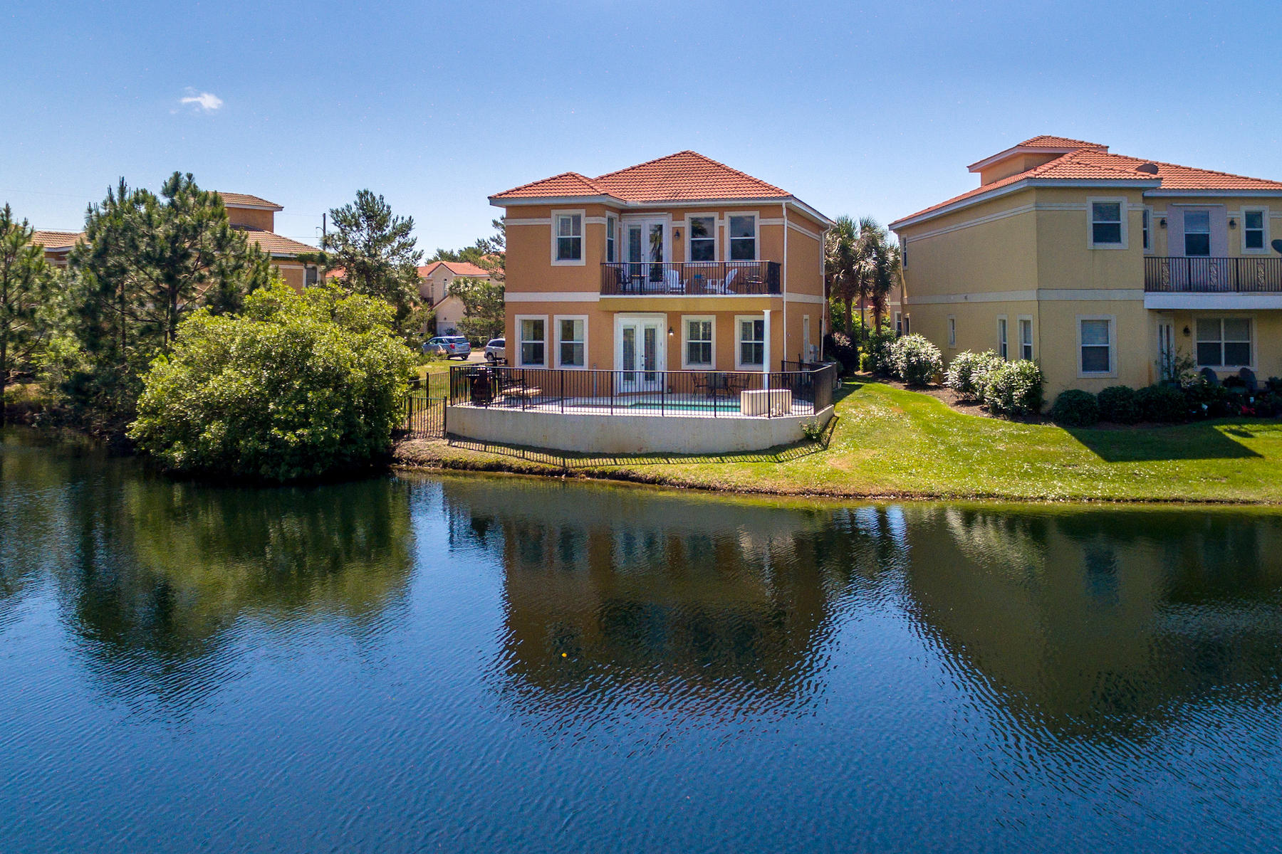Lakeside location and private pool, rare finds in gated Calusa Bay. Situated on the lake with views of the 5th fairway of Regatta Bay's award-winning golf course, 262 Calusa Bay offers the best of Emerald Coast living and recreation. This Tuscan-style, custom-built Florida home enjoys extensive upgrades, timeless design, and plenty of alfresco living. The lakefront deck features a sizable pool with a unique waterfall feature, covered patio area, and grilling station. The kitchen delivers stainless steel appliances, a large breakfast bar, and ample workspace. The master suite offers a private, lakefront balcony and spacious en suite with spa tub and glass enclosed shower. Gated Calusa Bay offers a community pool and pedestrian walkway to Regatta Bay's semi-private course and restaurant. Upgrades include a gated dog run, high-impact windows, custom plantation shutters, in-wall pest control, reinforced concrete retaining wall under pool, and more.