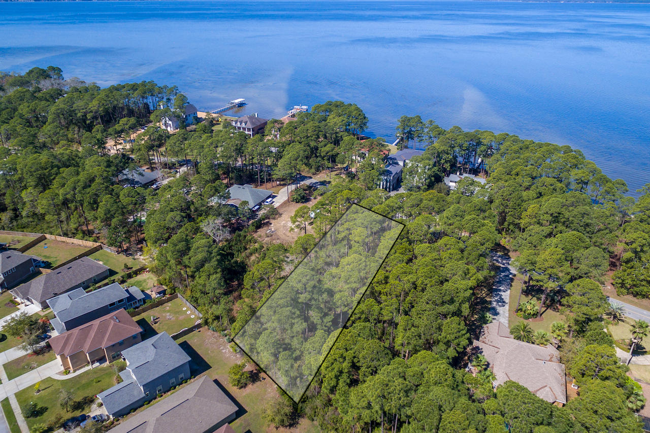 A gem of a homesite with mature towering trees. Whether you choose to build a cozy bungalow, classy contemporary, or rustic ranch, flexibility reigns here. Capitalize on bay water views, across the street, while preserving a natural woodland of privacy. With 0.624 acres you have space galore for your house plan. Have fun designing window placement to capture the changing light of the day and to maximize natural air flow. A 2-story home would maximize water views while a one-story abode would have all the advantages of single story living. With its park-like setting you will have the creative freedom not often found in this region. This lot is located near the point of a charming peninsula enveloped by Choctawhatchee Bay. While you will revel in the privacy, this bay front community is also super convenient to Sandestin Resort, Grand Blvd, restaurants, medical services, shops and water recreation.