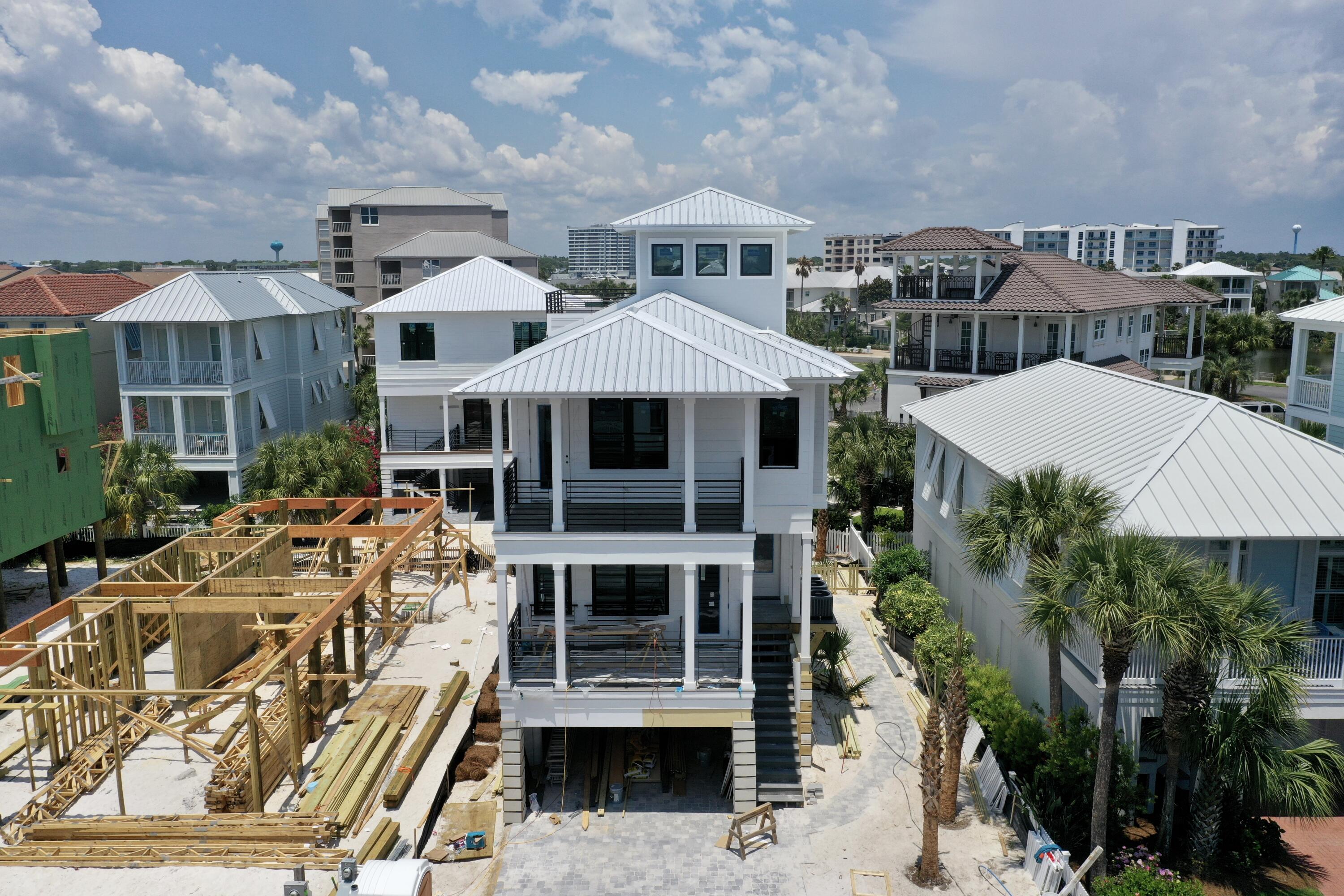 Rare opportunity to own a beautiful, brand-new construction in Destin Pointe! This home has it all, boasting upgrades galore on all four levels with tons of natural light and shiplap wall accents throughout. The first floor offers a partially covered, heated saltwater pool with a brick paved deck. The main level boasts open concept living with kitchen, dining and living room flowing into the spacious front deck. The chef's kitchen is equipped with a ZLINE gas range, Kitchen Aid appliances, Brizo luxe fixtures and faucets, quartz countertops, floating shelves, and soft close cabinets. Just beyond, you'll find a lovely private bedroom, including an ensuite bath and large private deck. On the third floor you will enjoy this home's 3 additional bedrooms along with a 5-bed bunk room. Two of these guest spaces boast room for king-sized beds, with one offering a secluded and spacious private deck. The luxurious owner's suite can be found here as well, where you will enjoy stunning gulf views from the peaceful, private deck. The fourth floor brings you to the lookout tower with incredible views in all directions. The conditioned tower room is perfect for entertaining or relaxing, while the gulf/pass facing deck is perfect for soaking in the magnificent views and relaxing with the soothing gulf breeze. Construction features include but are not limited to: a robust HVAC system, durable composite decking, Navien tankless water heater, high quality LVP flooring, Hardie board siding, custom railings and handrails, spray foam insulation throughout, and standing seam metal roof. Expertly designed with livability and comfort in mind, this beautiful beach home will exceed your expectations as a primary residence, vacation getaway, or investment property with revenue projection of $210K! Destin Pointe is an exclusive beachside community in the heart of Destin offering over 3,000' of private beach access, two community pool areas, tennis courts, two lakes, shuffleboard, seasonal beach shuttle, and 24-hour security. Within minutes to shopping, dining, entertainment, and world class beaches, this home is sure to impress in all aspects. Call today to schedule your showing!
