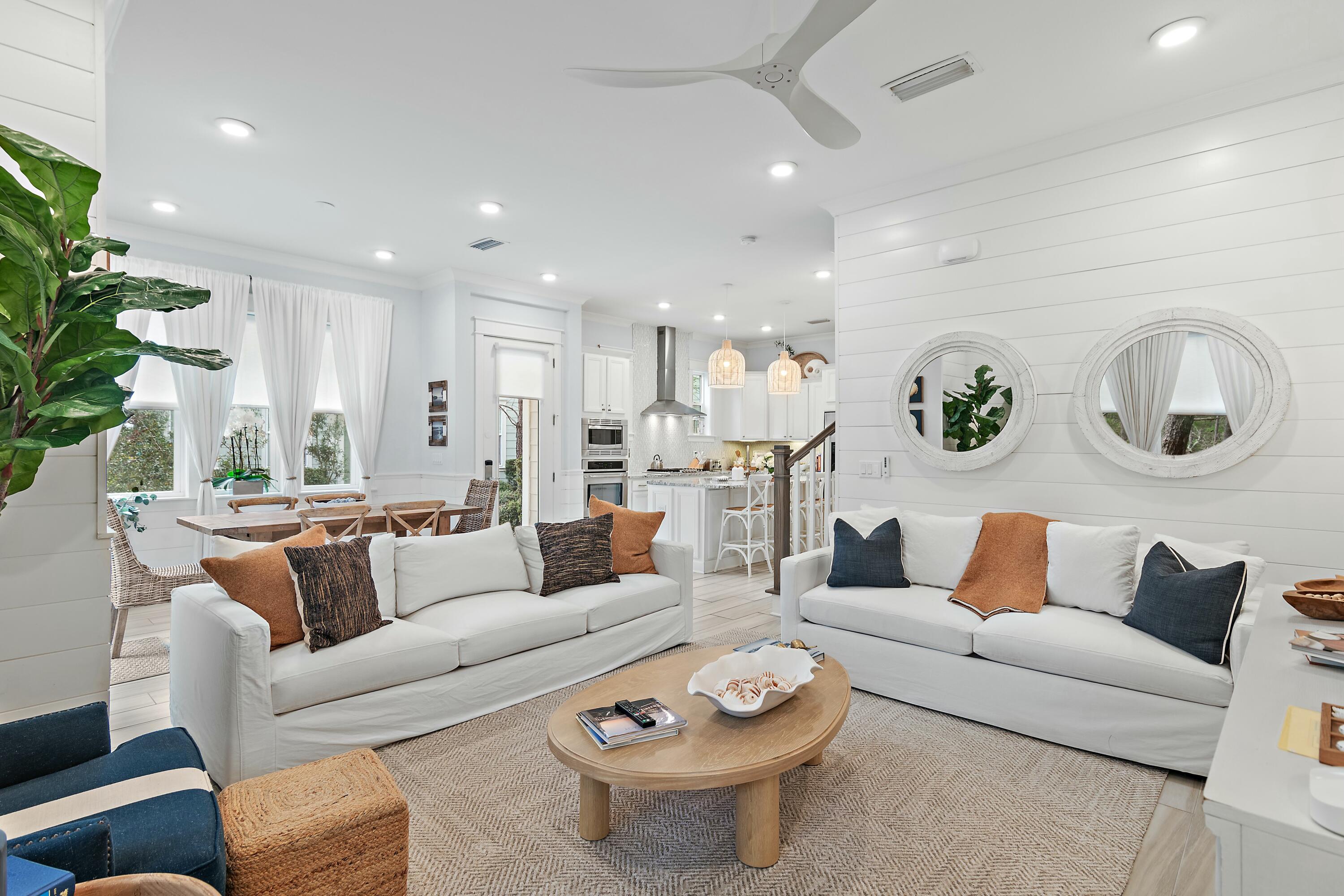 Backing directly to Deer Lake State Park, this 3BR/2.5BA ''Bahamas'' plan offers rare privacy with protected forest views and expanded green space between buildings -- one of the most desirable settings in Prominence. Sold fully furnished and turnkey with over $40,000 in furniture and lighting upgrades, this 1,679 SF townhome is ready for immediate short-term rental income, second-home use, or full-time living.  This unit has been owner occupied and meticulously maintained - simply bring your suitcase and enjoy! The open-concept main level features 10' ceilings, a spacious chef's kitchen with oversized island, dining for eight, and French doors leading to a private deck overlooking wooded pine lands. Upstairs, all bedrooms are thoughtfully arranged, including a vaulted primary suite with dual vanities and glass-enclosed shower, plus a queen guest room and full-over-full bunk room to maximize occupancy. Two-car garage with owner storage provides ample space for golf cart, bikes, and beach gear. A new 2023 six-seater golf cart (valued at $18K+) is available with acceptable offer. Prominence amenities include two resort-style pools, fitness center, green space, seasonal beach shuttle, and immediate access to The Big Chill. Minutes to Rosemary, Alys, Seaside, and Seagrove.