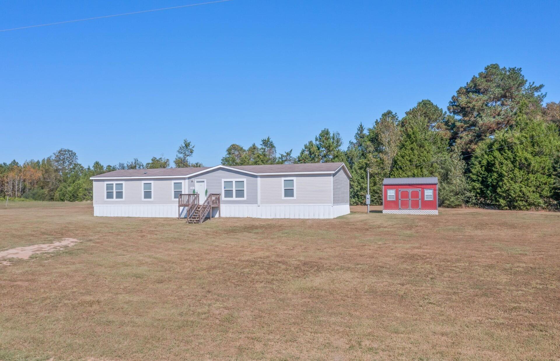PRICE REDUCED! Open House 4/18 11-3. This beautifully maintained 4-bedroom, 2-bath home blends country charm with modern comfort on 1.43 peaceful acres. Features spacious living and dining areas, a large kitchen with abundant cabinetry, ample counter space, and a breakfast nook. A barn door opens to a private flex nook with built-in shelving. The primary suite offers dual sinks, a soaking tub, separate shower, and walk-in closet. Three additional bedrooms provide space for family or an office. Enjoy a large yard perfect for gardening, entertaining, or adding a pool.  Stroll to Wayside Rock Bottom Park that's just a short distance from your front door. There is easy access to Highway 90 and I-10, and just an hour's drive to the beach, this home offers peaceful living with modern convenience