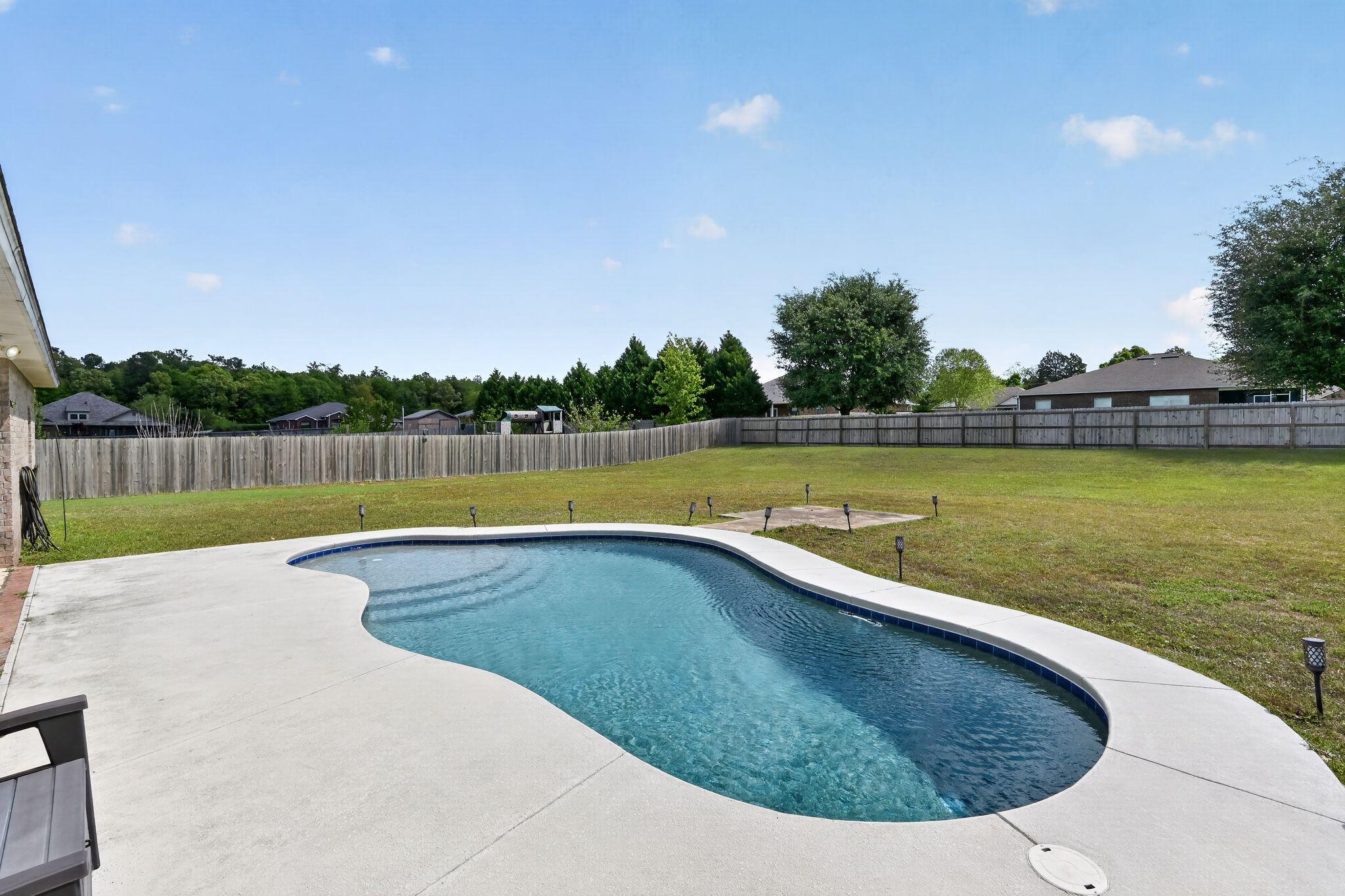 Spacious 4BR/2BA home on a flat 1/2 acre lot in Carnegie Hills! Features over 2,300 sq ft with a split floor plan, large living areas, and vinyl flooring throughout. Enjoy a private backyard with a saltwater pool and covered patio perfect for entertaining. HVAC replaced in 2022. Conveniently located near Hwy 85 with easy access to shopping, dining, and I-10. Great opportunity to add value and customize.