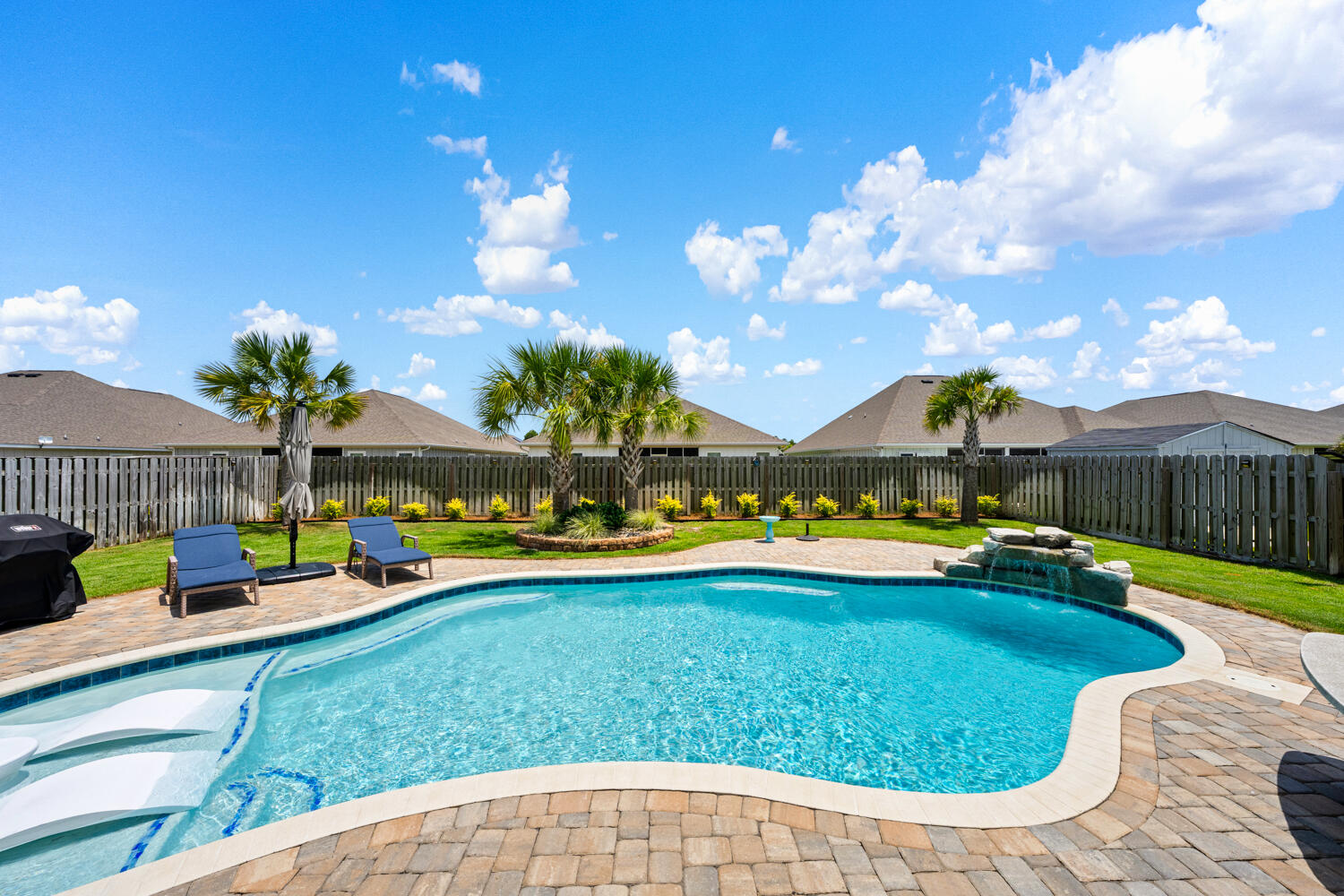 Experience resort-style living in this exceptional 4-bedroom, 3-bathroom, 3-car garage home, where premium finishes and high-performance upgrades deliver unmatched comfort and value. The backyard is a private oasis featuring a custom Gunite pool with a tanning ledge, waterfall, in-pool chaise loungers, and propane pool heater. The sunroom is designed for bug-free entertaining with a motorized high-impact screen engineered to withstand flying debris and high winds, plus premium Ninja Floor Coating--a non-porous, UV-stable surface that is four times stronger than traditional epoxy and heat resistant. A full guest bath just off the sunroom offers convenient access for pool guests. Built for peace of mind, this home includes a Propane Generac Guardian 24kW whole-home generator, aluminum hurricane shutters, a gutter and French drain system, and an automated sprinkler system. Inside, enjoy a complete AquaPro system with whole-house air purification, water softener, and whole-house water filtration. The inviting living room showcases a beautiful shiplap accent wall. The smart home system adds modern convenience. The layout includes a private guest suite separated by sliding barn doors, ideal for guests or multi-generational living. The luxurious primary bath features Italian porcelain tile flooring and shower, a Toto heated bidet, and towel warmer. The kitchen offers granite countertops, under-cabinet lighting, and double-sided island.