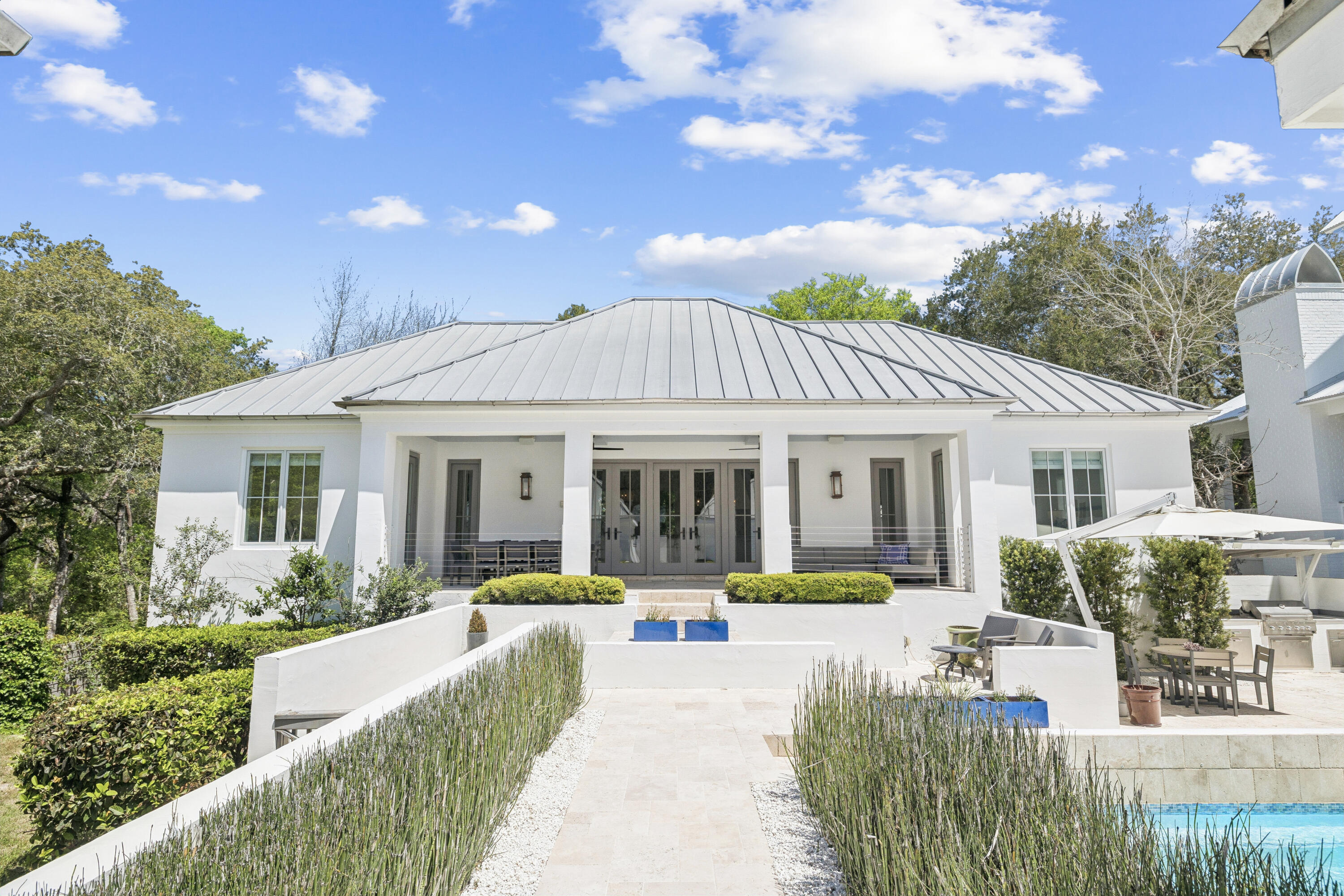Located in the heart of Old Seagrove, this private beachside compound offers upscale coastal living just steps from the sand and from Seaside and Watercolor. This thoughtfully designed and gated property features a main residence, carriage house, and a beautiful courtyard with a resort-style pool. The interior living space is anchored by a finely appointed chef's kitchen complete with custom cabinetry, waterfall countertop, and stainless steel Thermador appliances, including a 48-inch gas range. Wide-plank oak wood flooring, custom millwork, and designer lighting extend throughout the home, while the open living area centers on a gas fireplace and is filled with natural light, creating a warm and inviting atmosphere. The main level includes three spacious king suites, each with a spa- -inspired bathroom featuring marble flooring and a glass walk-in shower. The lower level offers a second living and game area, a bunk room with queen-over-queen beds, and two additional bedrooms for added flexibility. Overlooking the pool, the ground level carriage house includes a rare full kitchen, bright living space, dining area, and king suite, ideal for guests seeking a more secluded retreat. With six bedrooms, six bathrooms, no HOA, and an unbeatable private location near dining, shopping, and beach access, this property is an exceptional opportunity to own a luxury home along 30A.