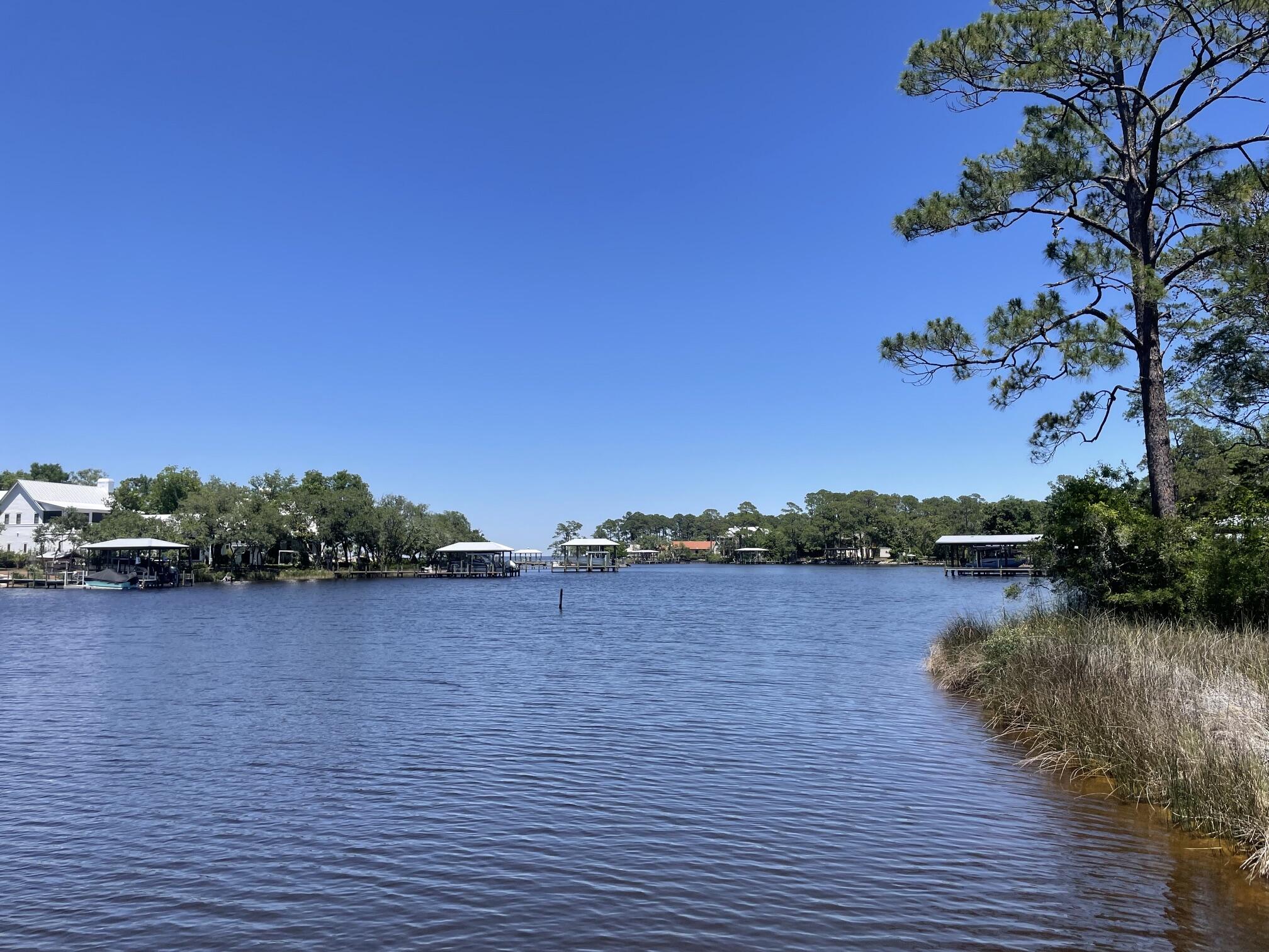 Waterfront 3BR/2BA cottage with stunning bayou views from almost every room. Screened-porch swing overlooks mature oaks and water. Primary suite features bay views, private sundeck, two walk-in closets, and separate vanity. Large kitchen w/ island opens to family room. Two screened porches, charming window seat in guest bedroom, and Mexican tile and carpet throughout. Includes boat dock & boathouse w/ lift. New roof 6/2025. New Carpet 5/26.Survey available. Unique Florida cottage you won't want to leave!