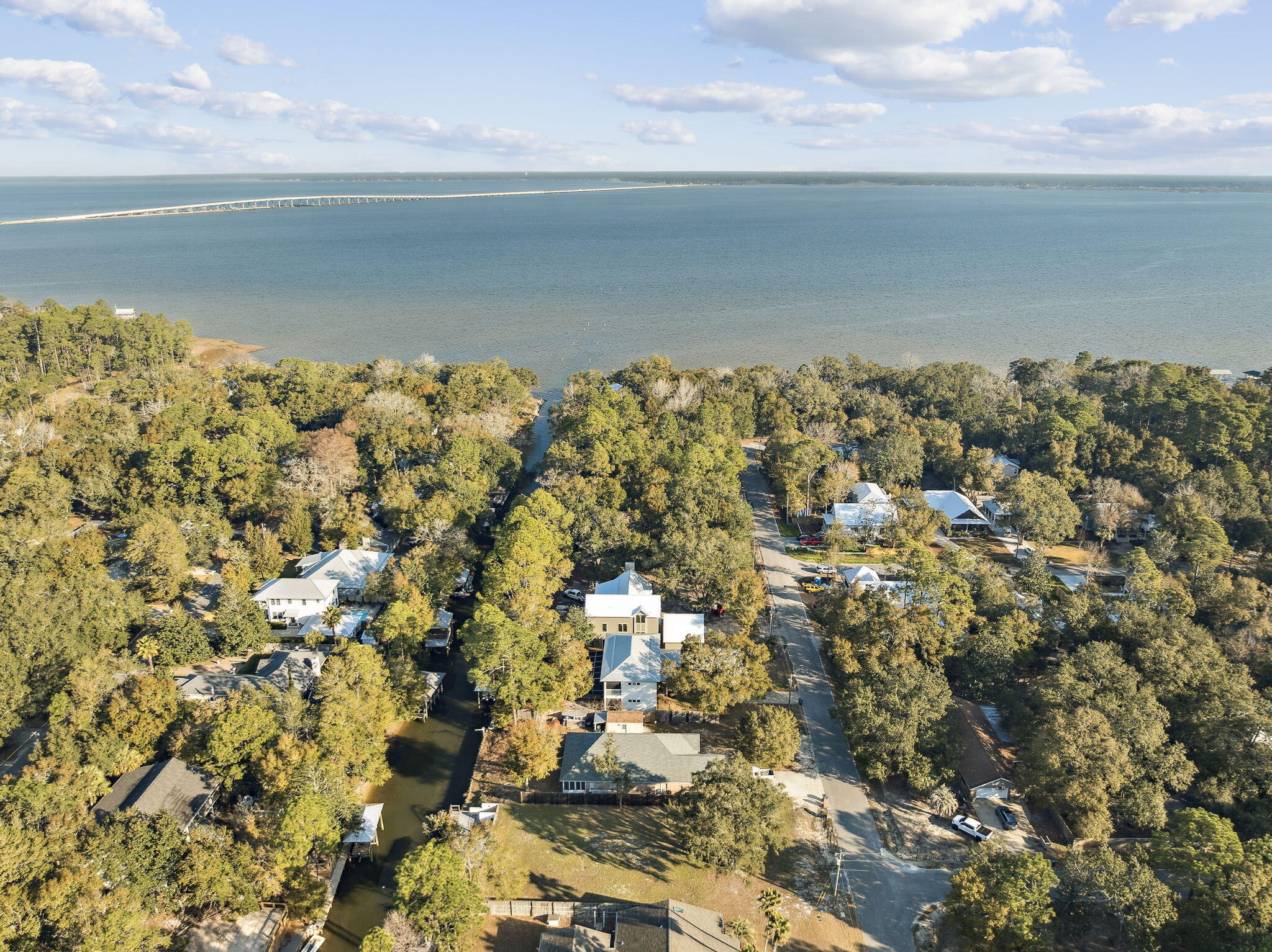 Waterfront living on Baker Canal at 143 Morrison Ave -- with quick access to 30-A shops and restaurants just south on CR 283, and a short boat ride to the Choctawhatchee Bay. The exterior features a dock with boat lift, outdoor fireplace, deck, two storage buildings, Hardie Board siding, and a metal roof. Inside, an open-concept family room and kitchen offer granite countertops, stainless steel appliances, ceramic wood grain flooring throughout, and generous closet space. Three large bedrooms each feature walk-in closets, complemented by 2.5 baths. Raised off grade for added peace of mind.