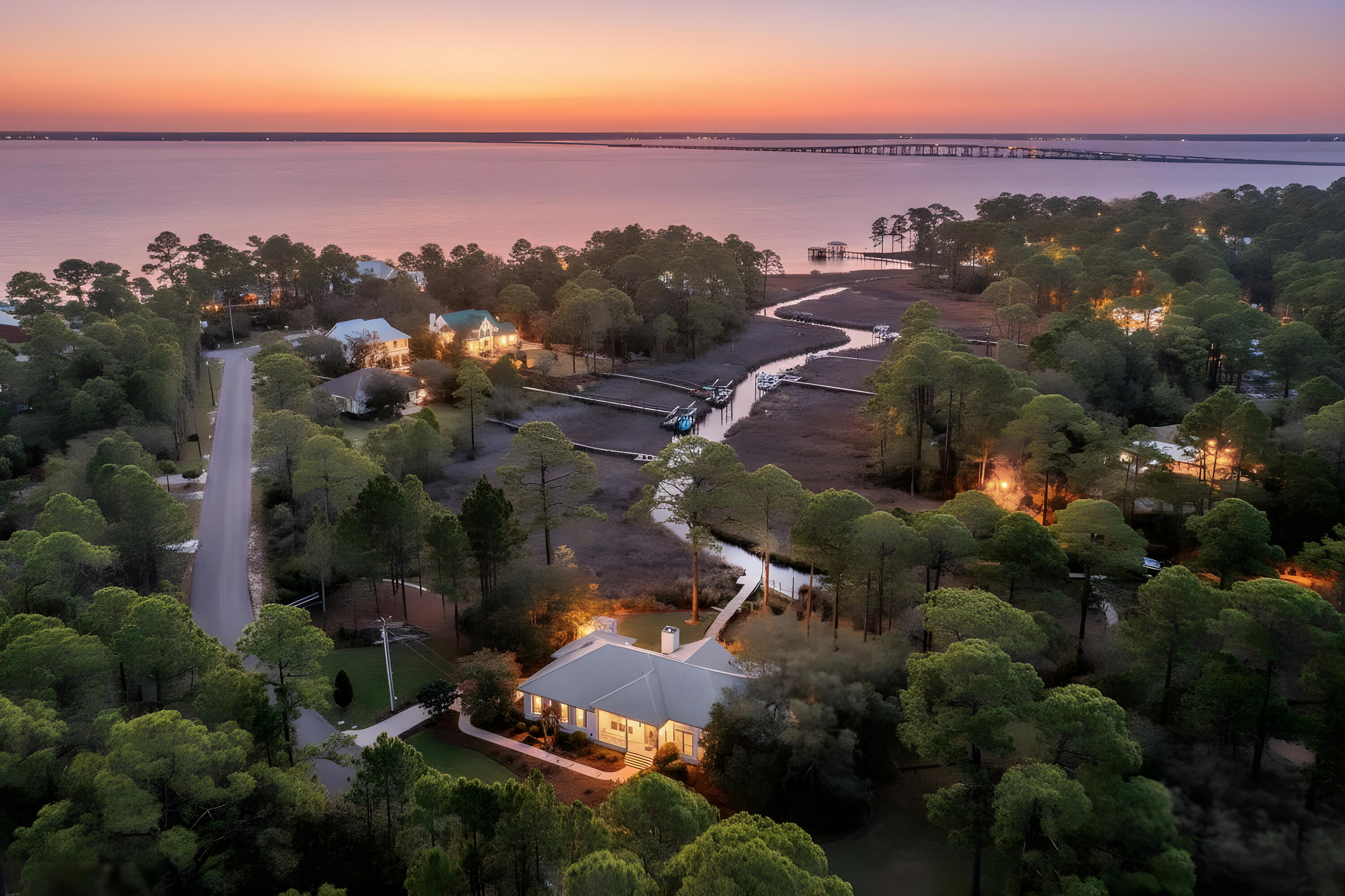 NEW PRICE! This rare 1.2-acre waterfront property of lots 27 & 28 is a truly distinctive navigable waterfront setting with sweeping views of a state protected estuary and Choctawhatchee Bay.  Here is a unique blend of natural beauty and privacy within the quiet upscale bay front community of Bay Pine Shores with paved Cul de sac streets.  The 325 ft. wide property provides privacy and has 230 feet of very navigable waterfront along Gurnee Creek with private dock for cruising into the bay and onward to the gulf for all types of water recreation and fishing. The owners obtained a state permit for an additional boat dock and lift and there is ample space to add a private pool and a carriage house.

This very thoughtfully updated, meticulously maintained custom-designed home has soaring ceilings, spacious, flowing living areas with scenic water views and outdoor connectivity from every room to porches and a large covered, screened porch.

The location of this home is just 4 miles from Gulf beaches, state parks, all that Scenic HWY 30A offers and close to nearby shopping, dining and Ascension Sacred Heart Hospital. A spacious, covered screened porch also captures the panoramic views, overlooking the peaceful setting surrounded by mature oaks, magnolias, azaleas, and camellias that create a quiet, park-like landscape.
Property upgrades include hardwood floors, a new guest shower, updated PEX plumbing, and freshly repainted walls and cabinets throughout, and feature a 40-year steel roof, an oversized garage, and generous driveway parking. A second large driveway accommodates a camper or boat, and an additional Florida Dock Permit offers the opportunity for a second dock and boat lift, if desired.
Ideally located just minutes from the Gulf beaches, Scenic Highway 30A, state parks, marinas, shopping, dining, and entertainment, and with convenient access to healthcare including Ascension Sacred Heart Hospital, this property offers a rare balance of waterfront privacy and everyday accessibility.