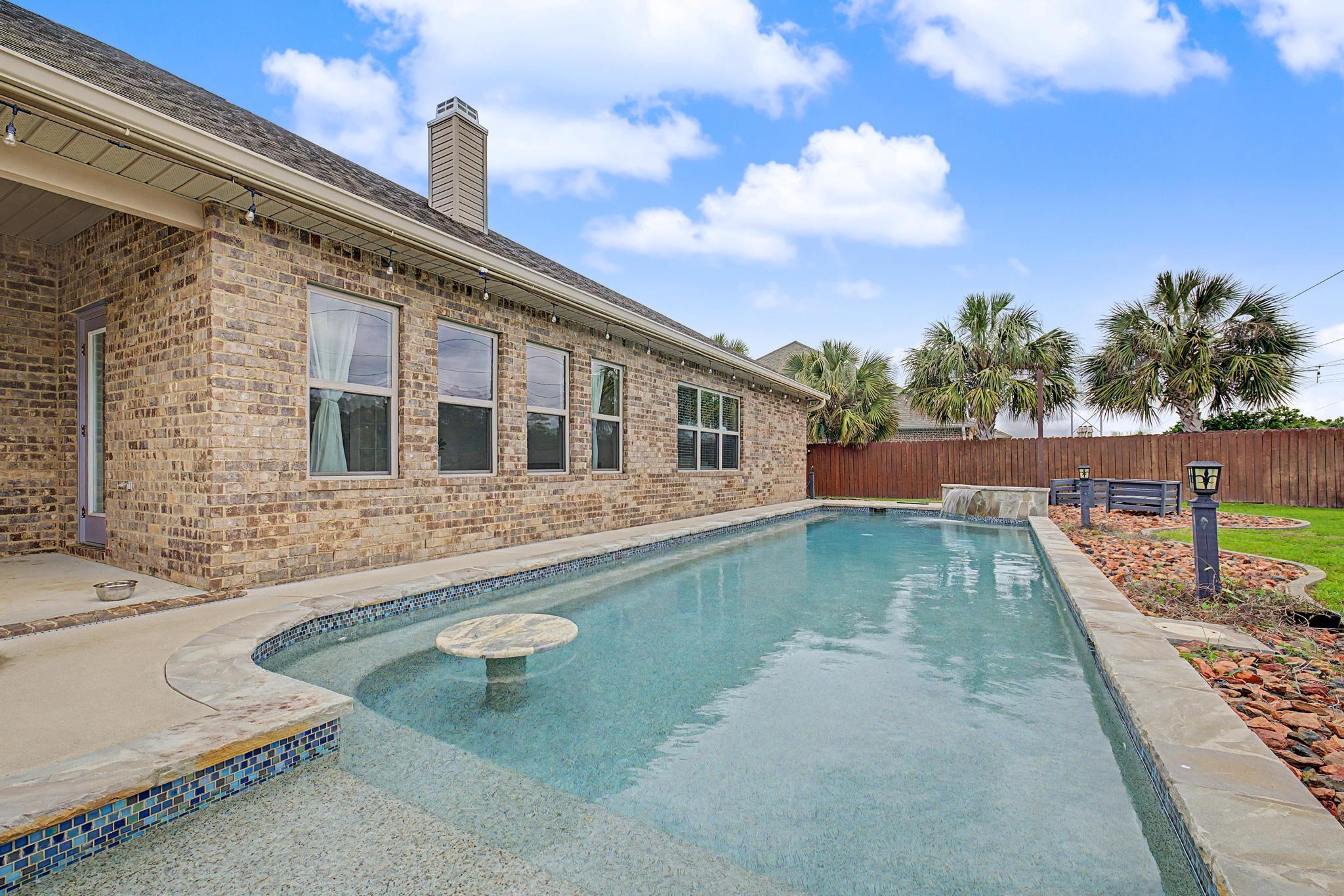 Imagine a life where space, privacy, and comfort all come together effortlessly.
From the moment you arrive, there's a quiet sense of ease--mature surroundings, a welcoming front porch, and a feeling that life naturally slows down when you pull in. This 3,356 sq ft pool home sits on a generous 0.67-acre lot and is designed for both connection and retreat. Inside, light-filled spaces, arched doorways, and an open flow create a natural sense of comfort and cohesion throughout. At the heart of the home, the kitchen becomes the gathering point with rich cabinetry, a large island, breakfast bar seating, and an inviting eat-in area that makes everyday moments feel intentional.  The primary suite offers a true escape with a sitting area, dual walk-in closets, and a spacious bath designed for unwinding at the end of the day. Step outside to your own private retreat--featuring a Gunite in-ground pool, covered patio, and fully fenced backyard. The additional space beyond the fence offers flexibility for RV or boat storage, adding a rare level of convenience and freedom. This is more than extra square footage--it's a home designed to feel open, functional, and quietly elevated, inside and out.