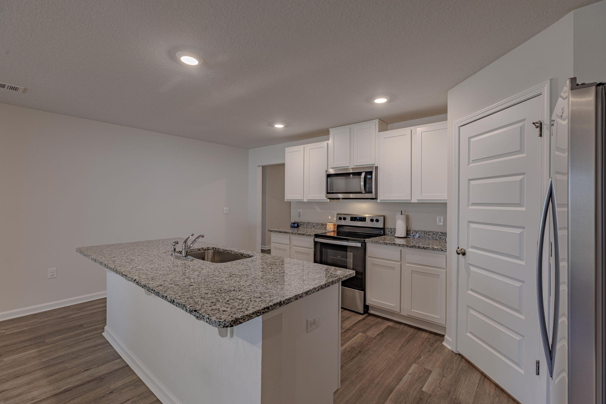 The popular Cali floor plan with 1,830 sq. ft. of well-designed space, backs up to wooded lot for maximum privacy and paid off solar panels at closing. The open kitchen boasts granite counters, stainless steel appliances, a large island, walk-in pantry, and smart home system. The primary suite offers a walk-in closet, dual granite vanity, large shower, and linen closet. LVP flooring throughout, carpet in bedrooms. Enjoy a covered patio and massive fenced backyard, perfect for a pool, shed, or play area. Solar panels installed to help lower utility costs! Move-in ready--schedule your showing today!