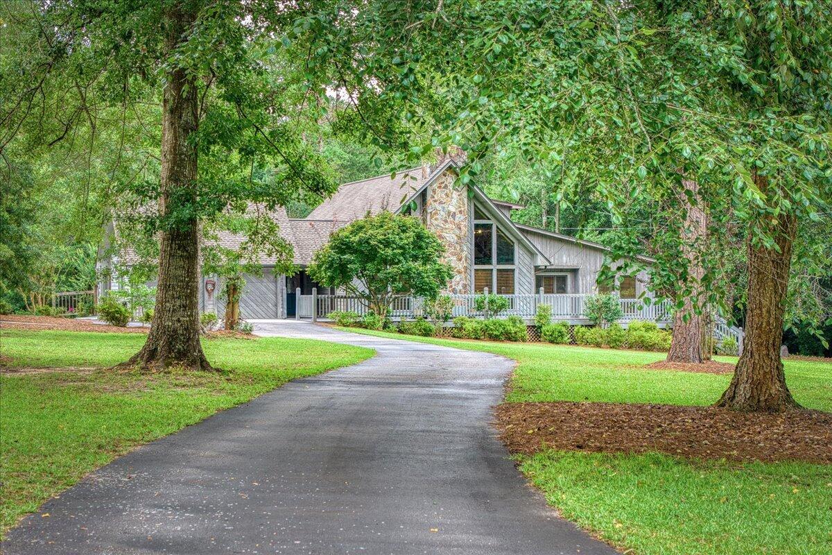 Welcome to your private retreat in Jay, where craftsmanship meets nearly 8 acres of peaceful Florida countryside! This is an exceptional opportunity to own nearly 8 acres with a blend of wooded privacy, open land ideal for gardening or hobby farming, and a creek bordering the property. Built and meticulously maintained by its original owners, this custom 4-bedroom, 3.5-bath POOL home offers updates including a 2023 roof, 2 HVAC systems replaced in 2020 & 2023, and a 2024 water heater. Being sold PARTIALLY FURNISHED this home is tucked off the road at the end of a winding driveway, inside features soaring 20-foot cathedral ceilings with cedar beams, floor-to-ceiling windows, hardwood floors, porcelain tile and a dramatic stone fireplace with a Buck Stove insert. The kitchen is designed with solid wood cabinetry, a center island with breakfast bar, and pantry. The family room is equipped with a built-in entertainment stand and direct access to the open deck makes hosting effortless. The primary suite includes a view of the pool, boasts a large walk-in closet, and an ensuite bath with a his and hers setup, equipped with dual-access pass-through shower. Two additional bedrooms are on the main level, each with walk-in closets. Upstairs, a loft leads to an oversized fourth bedroom with cathedral ceilings, attic storage, a large walk-in closet, and a beautifully updated bath with double vanities and a tiled walk-in shower. Outside, enjoy your private pool surrounded by composite dec king, mature landscaping, and a covered gazebo with an attached closet to store pool equipment. A bathroom is conveniently accessible from the pool area. Additional features include a two-car garage with two storage rooms, a one-car carport with attached storage, Vacuflo central vacuum, Aquasana whole-house water filtration, security system, and irrigation supplied by a private well. This one-of-a-kind property offers the perfect combination of seclusion, outdoor living, and room to grow!