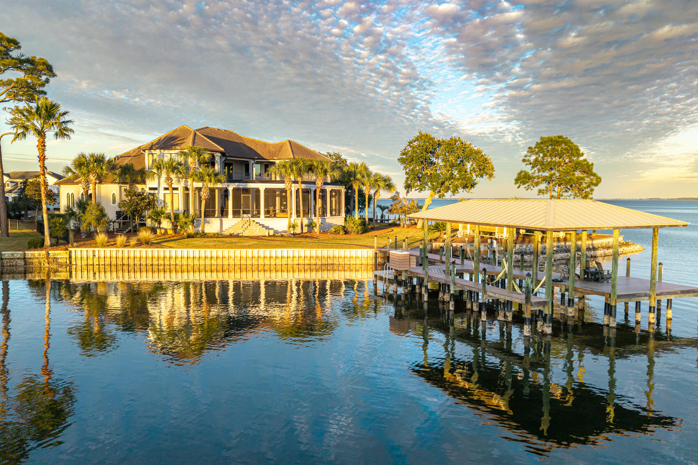 This extraordinary bay front estate is tucked at the end of a quiet cul-de-sac within the gated enclave of Grand Cove in Santa Rosa Beach. It captures the essence of coastal luxury with over 350 feet of shoreline along the serene waters of the Choctawhatchee Bay.  A rare offering, this is more than a home--it's a private retreat where sweeping views, thoughtful design, and effortless indoor-outdoor living come together.

Recently and tastefully renovated, the residence now showcases a fresh, open-concept floor plan designed for both elevated entertaining and relaxed coastal living. The heart of the home is a beautifully reimagined kitchen featuring new stone surfaces, premium appliances, and generous gathering spaces, all seamlessly flowing into the main living areas. New LVP flooring enhances the warmth and sophistication, while expansive windows and French doors invite in natural light and uninterrupted water views at every turn. New designer lighting adds to the home's appeal throughout while neutral and tasteful furnishings (included) invite relaxation. 

The main-level owner's suite is a true sanctuary, offering tranquil views of the cove and direct access to the resort-style outdoor spaces. Thoughtfully designed, it includes dual walk-in closets, a spa-like bath, and private spaces for work or wellness.

Well-appointed guest accommodations ensure comfort and privacy, with elevated vantage points that continue to showcase the home's stunning waterfront setting. Now configured as a 4-bedroom residence, the layout is both functional and refined.

Outdoors, the lifestyle truly comes alive. An expansive pool and spa are surrounded by generous lounging, entertaining, and grilling areas, all framed by the natural beauty of the water. The private dock--with covered boat lift and jet ski access--extends your living space onto the cove, inviting days spent boating, paddleboarding, or simply enjoying the view.

With its rare combination of privacy, water frontage, and curated renovation, this is a true estate property--luxurious yet inviting, designed for making lasting memories on the water.