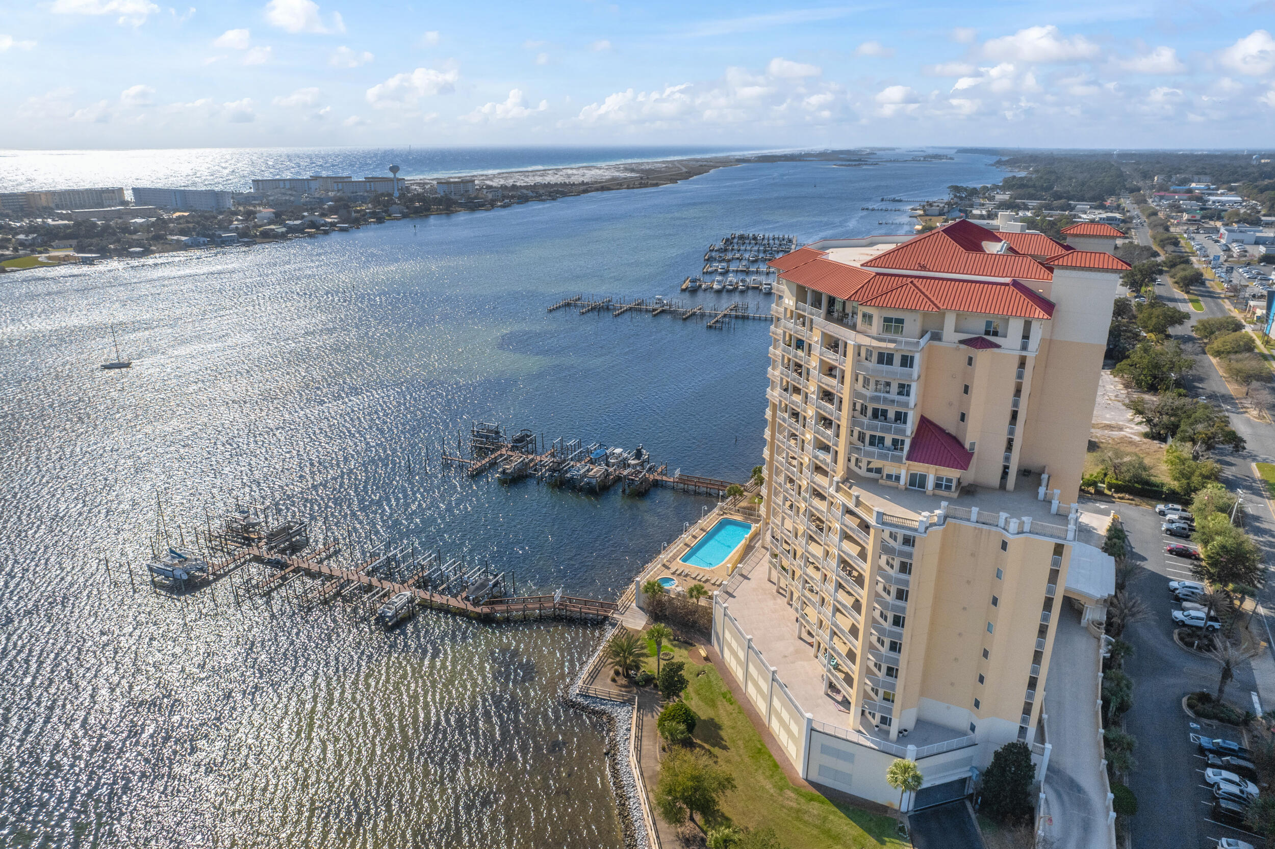 Come experience luxury living at Presidio Yacht Club, one of Fort Walton Beach's most prestigious waterfront communities! Presidio offers high-end amenities including a pool overlooking the water, hot tub, marina, dock for fishing, theater room, owners' community lounge, fitness center overlooking the water, and a guest quarters for visitors. A covered marina is located .8 miles down the road - Fort Walton Beach Yacht Basin. This beautifully updated condo offers fresh paint, new flooring, a renovated bathroom and updated kitchen, creating a home that truly shines. Step onto the expansive balcony and take in breathtaking 180-degree views of the Santa Rosa Sound, Gulf, and Choctawhatchee Bay. A rare feature of this unit is two deeded parking spaces located in the gated, covered garage and a storage closet just across the hall from the front door! Inside, the open living area boasts elegant tray ceilings and crown molding, with a wall of windows framing the gorgeous water views. The spacious kitchen is designed for both function and style, featuring abundant cabinetry, a large island with breakfast bar, pantry, updated appliances, and stylish lighting. Just off the kitchen, a dining area provides the perfect spot for everyday meals or entertaining. The split primary suite offers ample space for a sitting area and direct balcony access. Its spa-like en suite includes a jetted tub, separate walk-in shower, dual vanities, a private water closet, and a generous walk-in closet with custom wood shelving. Each guest bedroom enjoys its own en suite bathroom, both recently updated with new tile, vanities, mirrors, and lighting. One features a brand new tiled standing shower. The two guest bedrooms are thoughtfully placed at the front of the unit, each offering privacy and comfort. From sunrise to sunset, this residence delivers the perfect balance of luxury and waterfront serenity!