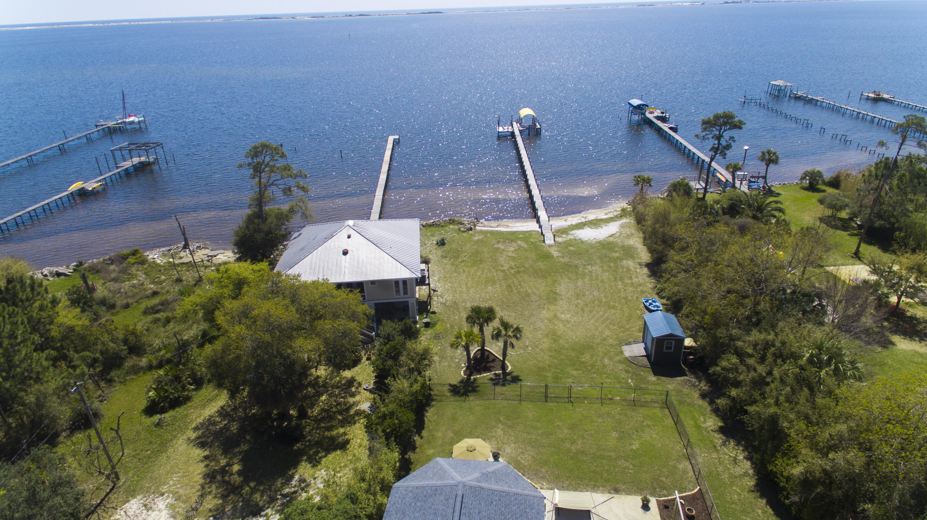 WELCOME HOME to Florida living at its best.This Simply Stunning custom built ICF 4 bed 4 bath home enjoys a tranquil water front lifestyle ~3900 sq. ft. of detail design and living with a Gorgeous 4 Seasons room to enjoy year round sunsets over the water~ BOARDWALK out to your COVERED BOAT LIFT and observation /tanning deck with BREATHTAKING VIEWS over the Santa Rosa Sound and National Seashore Island. The present owners have lovingly transformed this custom built home and the attention to detail and floor plan is paramount~Wrap around front porch with door access to the garage and fitted storm shutters~Grand double door entrance to your welcoming foyer with open flow to the large dining area and formal living room with French doors out to the 4 seasons room with floor to ceiling sliding windows and stone stacked gas fireplace. Library/office with built in book shelving and glass paneled doors. Gorgeous Gourmet kitchen with trend setting painted cabinets ~soft Touch under cabinet lights~Custom Hammered Metal Farmhouse Sink ~ S/S convection double oven and gas top stove ~Large L shaped Granite Island with prep sink and lazy Susan storage~walk in pantry ~breakfast area which is large enough to accommodate a coffee station~ all free flowing to the Grand main family room with high ceilings and soaring picture windows overlooking the garden and picturesque water view ~. Family room also has double doors to the season's room and access to the beautiful back garden. Master is comfortably off set from the main living area for additional privacy and overlooks the water with access to the back garden .Master bath ~his and her closets, linen and over sized step in cultured marble shower separate vanity sinks and private W/C with sink. Arched hallway leads to the 2 additional bedrooms with large double closets and additional bathroom with cultured marble vanity, wc and step in shower/tub. Additional visitors bathroom is located off the formal living room .Stairs lead to a huge bonus room, 30 x 24, with built in nook bed with storage drawers and Dorma window~ has its own bathroom with shower and a huge separate closet/storage area. .Laundry room has built in shelving and leads out to the Over sized 2 car garage with fitted cabinets ,mop sink and back door out to the side yard just add to the versatility of this wonderful family home .The true custom design offers views of the Santa Rosa sound and gorgeous Island  from  nearly every room  .Step outside to enjoy the elevated location  ~ Huge beautifully landscaped grassed yard and extended patio which is partially fenced and has a sprinkler system for easy care in the summer months ~ workshop/shed to keep all your water toys .....237' Boardwalk to the water and there your serenity begins to sit out and enjoy the beauty of the Santa Rosa Sound and breathtaking sunsets~,...this truly is a tranquil paradise you have to see to enjoy ~Home offers many detailed extras ~fully fitted Hurricane Shutters or impact windows~3  Zone A/C ~Termite Bond~To name a few....make an appointment today for a personal tour of this breathtaking retreat