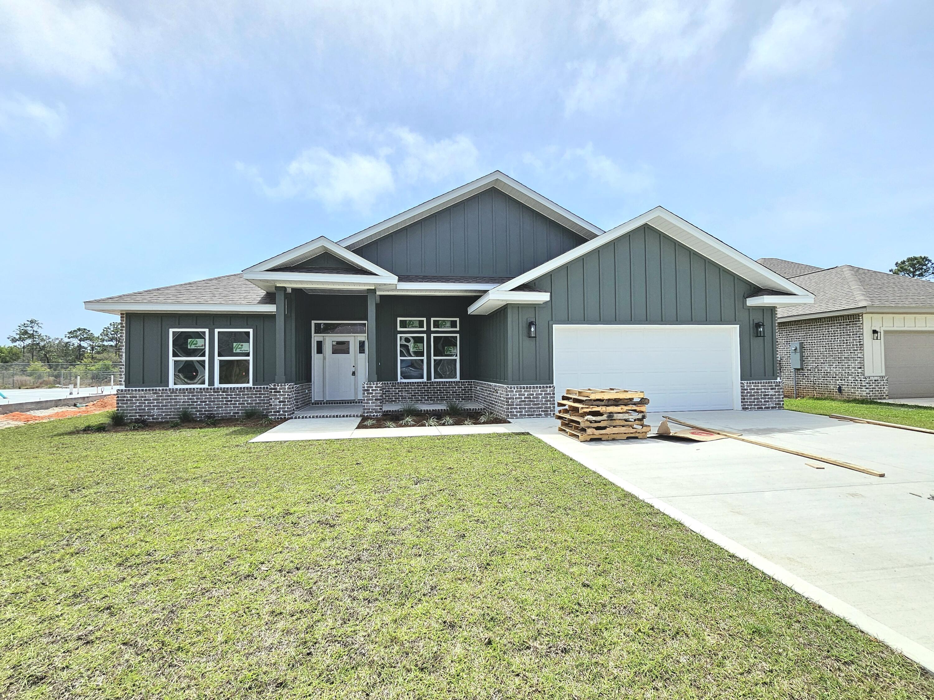 ***UNDER CONSTRUCTION - READY FOR OCCUPANCY MAY 2026*** Affordable luxury can be yours! Beautiful BRAND NEW 4 bedroom/3 bath modern craftsman style home in Gulf Breeze ready for occupancy now. Attractive brick & hardie-board exterior with covered front porch invites you inside to a wide open floor plan with high ceilings throughout & many upgraded features. Luxury vinyl plank flooring throughout the entire home - no carpet here! Spacious living room with French doors leading to the back porch and tons of natural light. Gorgeous and thoughtfully designed kitchen features white shaker cabinets, sparkling Quartz countertops, glass tile backsplash, center island with breakfast bar, pantry and stainless steel appliances including gas range and beverage cooler. Triple split-bedroom floor plan offers private guest suite with attached full bath that has access to back porch. At the rear of the home is the luxurious primary suite, with a spacious primary bedroom with sitting area, en-suite bath with double vanity, freestanding bathtub, and huge walk-in shower, and a walk-in closet which connects to the laundry room. Huge covered back porch and fully-fenced backyard create the ideal outdoor living space. All this, just 1 mile to Woodlawn Beach boat launch & new Soundside High School!