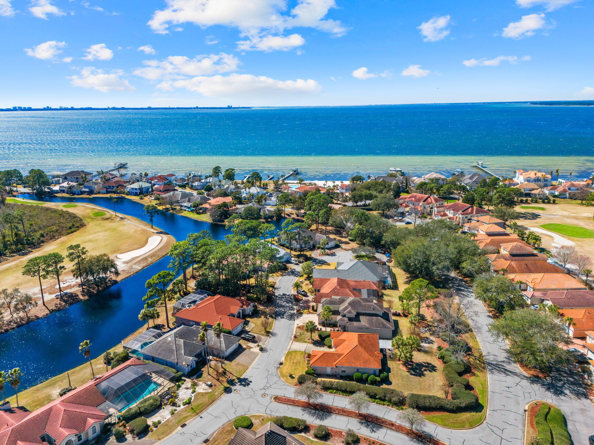 See Additional Remarks--- Experience refined coastal luxury at 4319 Sunset Beach Circle, a custom-built residence in the exclusive guard-gated community of Sunset Beach within Bluewater Bay. Offering 3,107 square feet of thoughtfully designed living space, this exceptional home blends elevated design, superior craftsmanship, and energy-efficient construction into one impressive package.

A pavered drive and Versailles-pattern travertine walk lead to a covered entry accented with tongue-and-groove wood ceilings and grand mahogany double doors with aged bronze hardware. Inside, natural light pours into the expansive main level where soaring ceilings and seamless travertine flooring connect the formal dining area, great room, chef's kitchen, and breakfast nook. The scale is both dramatic and welcoming, perfectly suited for intimate evenings or larger gatherings.

Extensive millwork, custom casings, and curated finishes elevate every space. The great room showcases 22-foot ceilings, statement chandeliers, a gas fireplace, and custom built-ins, all flowing effortlessly into a designer kitchen outfitted with professional-grade stainless steel Viking appliances, including dual convection ovens, a five-burner gas range with pot filler, and a Viking refrigerator. An oversized island with prep sink and beverage station anchors the space, while soft-close cabinetry and a generous walk-in pantry provide abundant storage without sacrificing style.

The primary suite is privately situated on the main floor behind double eight-foot doors, offering a serene retreat with a spa-inspired bath featuring dual vanities with Carrara marble tops, a soaking tub, walk-in shower with dual heads, private water closet, and spacious walk-in closet.

Outdoor living is equally impressive. French doors and sliding glass panels open to a large covered porch complete with tile flooring, wood-paneled ceilings, and ample space for lounging or dining. Pre-plumbed for gas, water, and electric, the area is ready for a future summer kitchen. Beyond, mature landscaping and a generous sodded lawn create a beautiful and functional backyard setting.

Upstairs, two oversized bedrooms each enjoy private en suite baths, while a fourth bedroom--currently used as an office--offers flexibility along with a finished, climate-controlled walk-in storage space.

Built with 2x6 construction, spray fiber insulation, and foam roof decking, the home is designed for efficiency and durability. A DECRA stone-coated steel roof with, NEW Rinnai tankless water heater, dual Lennox heat pumps, Manabloc plumbing system, surround sound, and Kevlar hurricane shutters further highlight the home's commitment to quality and performance.

Residents of Sunset Beach enjoy exclusive access to Niceville's only bayfront, resort-style pool, private sandy beach, clubhouse, and 24-hour manned security, with HOA dues that include lawn maintenance and lawn irrigation.

A custom home of this caliber, in this location, is a rare offering--thoughtfully designed, impeccably finished, and positioned within one of Niceville's most desirable waterfront communities.