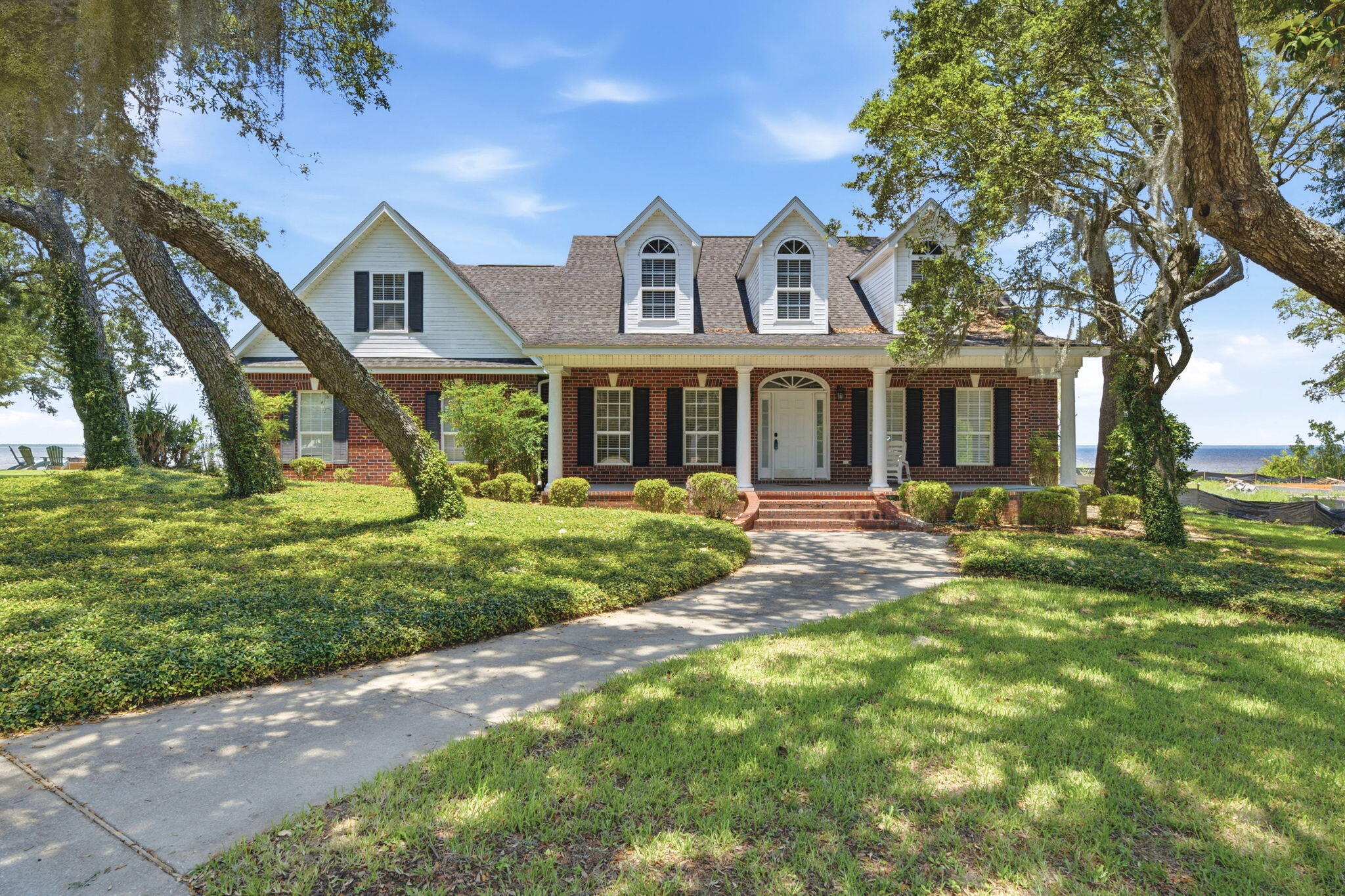 Welcome to this charming colonial-style, bay-front estate - nestled in the highly sought-after Hickory Shores area of Gulf Breeze. Offering an incredible canvas for those looking to create their waterfront ''home sweet home''. Starting with the circular driveway and side-entry 2 car garage to provide ample parking space. An inviting, oversized covered front porch greets you upon arrival - and is just waiting to be the backdrop for your morning cup of coffee in a rocking chair. Wrap-around sidewalk paths lead you around either side of the house to the backyard, through the oak trees and landscaping. Enjoy 106 waterfront feet - with a decking lined stairstep path leading you down to your very own private dock area on the bay - offering the most incredible view. The home offers a functional split floor plan with 3 bedrooms, 2 and a half bathrooms, versatile upstairs bonus room, formal dining room, dedicated office space with french doors, inside laundry and utility room, and a sweeping, open concept main living space that seamlessly blends the kitchen and living areas and features a soaring vaulted ceiling with tons of natural light and waterviews all around. The primary suite serves as a peaceful retreat, showcasing its own amazing waterfront view from both the bedroom and ensuite bathroom. The oversized, covered patio serves as a true extension of your living space - perfect for outdoor entertaining and all fresco dining. With its classic charm, good bones, generous proportions, and an irreplaceable waterfront location, this property is a rare find ready for the right vision to restore its full potential!