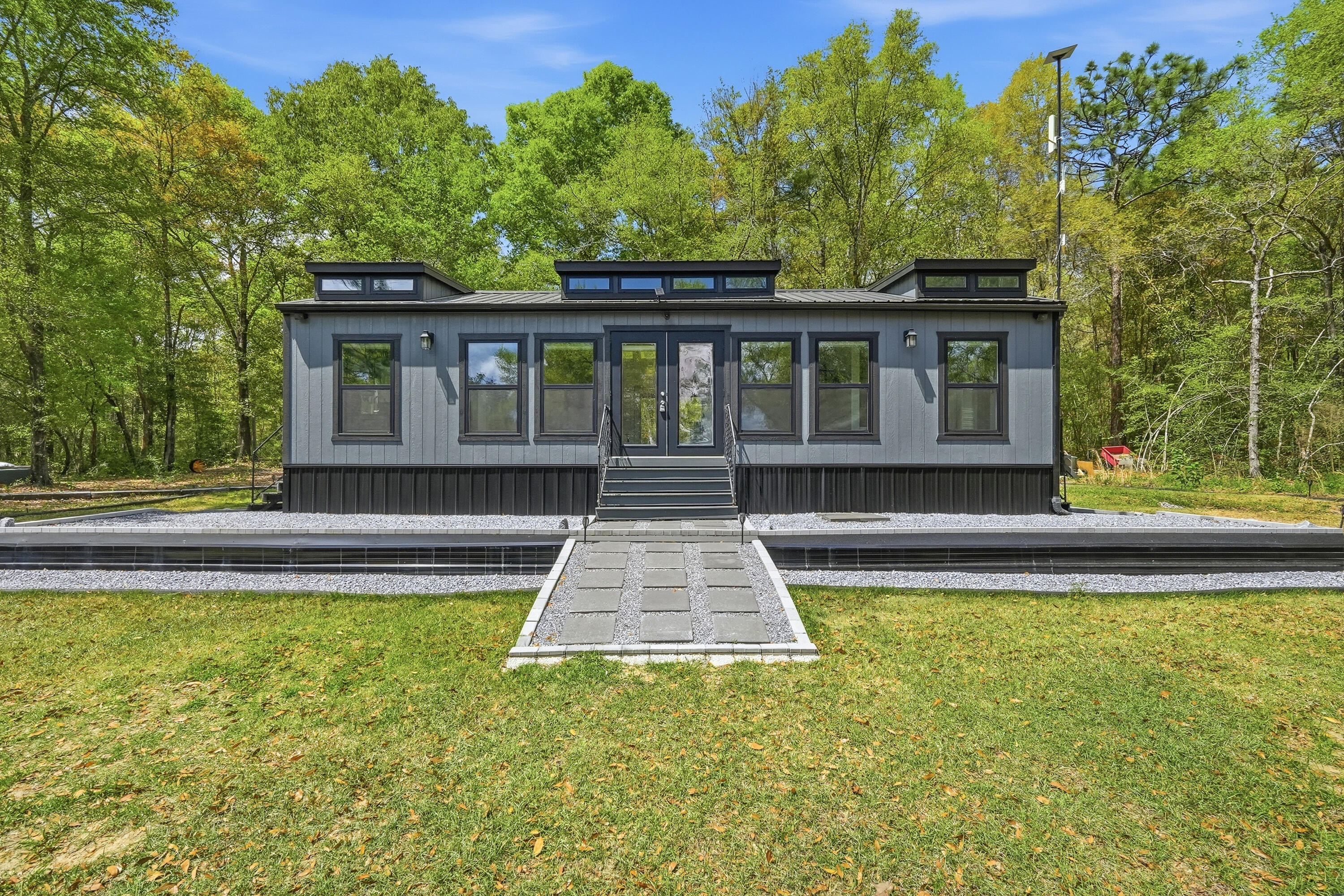 **Tiny Home Living on 4 Acres of Lakefront Paradise**

Welcome to a rare find in the heart of Northwest Florida -- a 2024 charming tiny  home  16x24 nestled on an expansive 4-acre waterfront parcel along the shores of Lake Holley a 400+ acre lake renowned for its trophy largemouth bass fishing. This is more than a home; it's a lifestyle waiting to be embraced.

The spacious 585-square-foot tiny home features 1 bedroom and 1 bathroom, offering a simplified yet comfortable living experience perfect for those seeking to downsize, invest, or create a peaceful retreat. Step outside, and the real magic begins. Approximately 132 feet of pristine waterfront greets you, complete with a private fishing dock where you can cast a line at sunrise or simply soak in the tranquil views. The property comes equipped with essential infrastructure already in place -- a well, a 2003 septic system, and electric service -- saving you significant time and investment. A convenient circle drive provides easy access, while a storage shed with covered parking adds practical functionality for boats, equipment, or vehicles.

Surrounded by natural beauty, you're just minutes from Shoal River Headwaters State Park and Walton High School a short drive into town. The sprawling outdoor space offers endless possibilities for expansion, gardening, or simply enjoying the peaceful Florida countryside.

Four-acre waterfront parcels on local lakes are incredibly hard to come by. Don't let this extraordinary opportunity slip away -- schedule your private showing today!