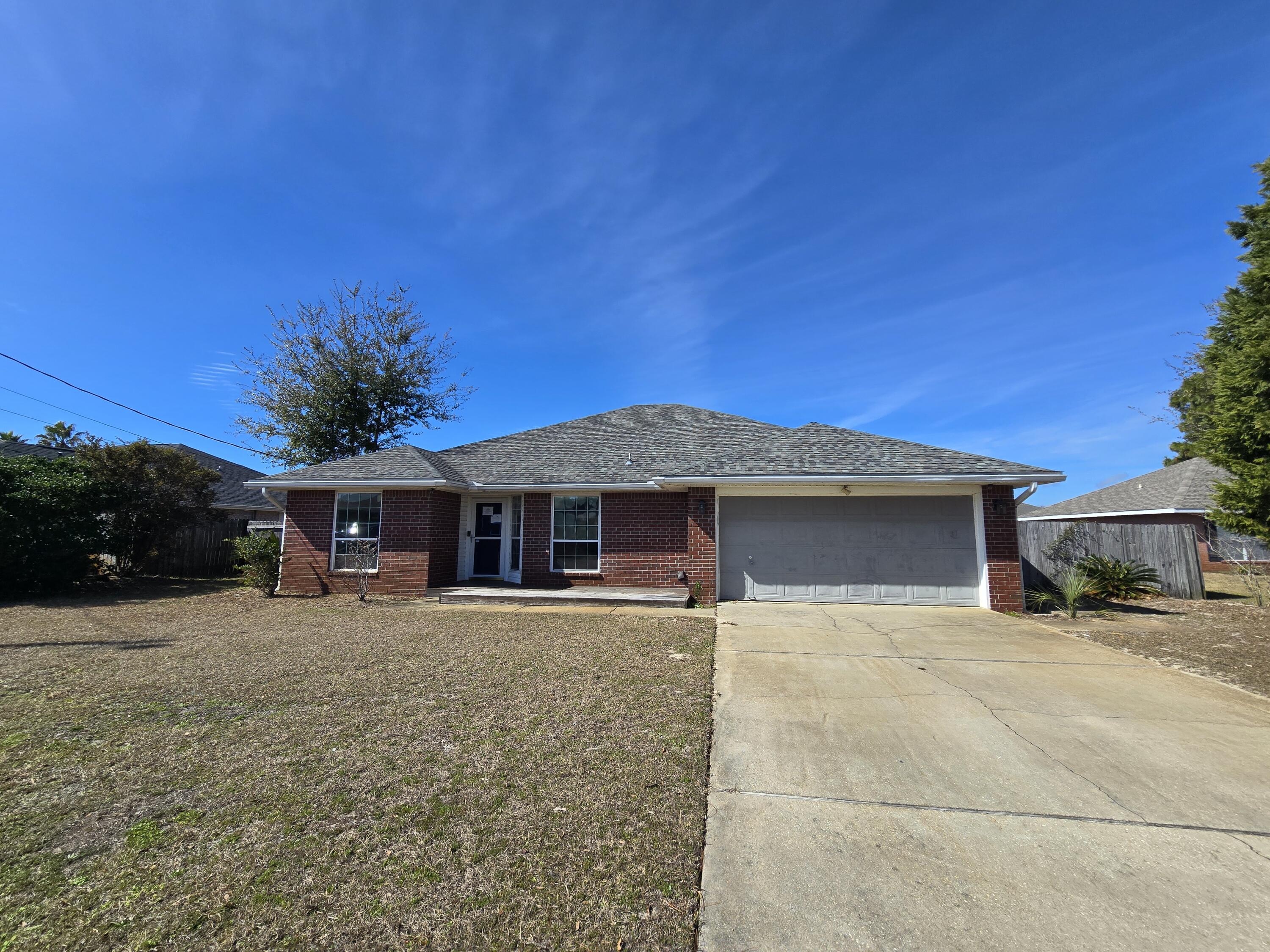 REO. Four bedroom, two bath home located on a cul de sac just two and a half miles from the white sand and the clear emerald waters of Navarre Beach!   Home features a split bedroom floorplan, kitchen dining room combo and a spacious great room. No carpet here. Tile and wood laminate throughout! The screened sun room runs the entire length of the back of the house and overlooks a privacy fenced yard.