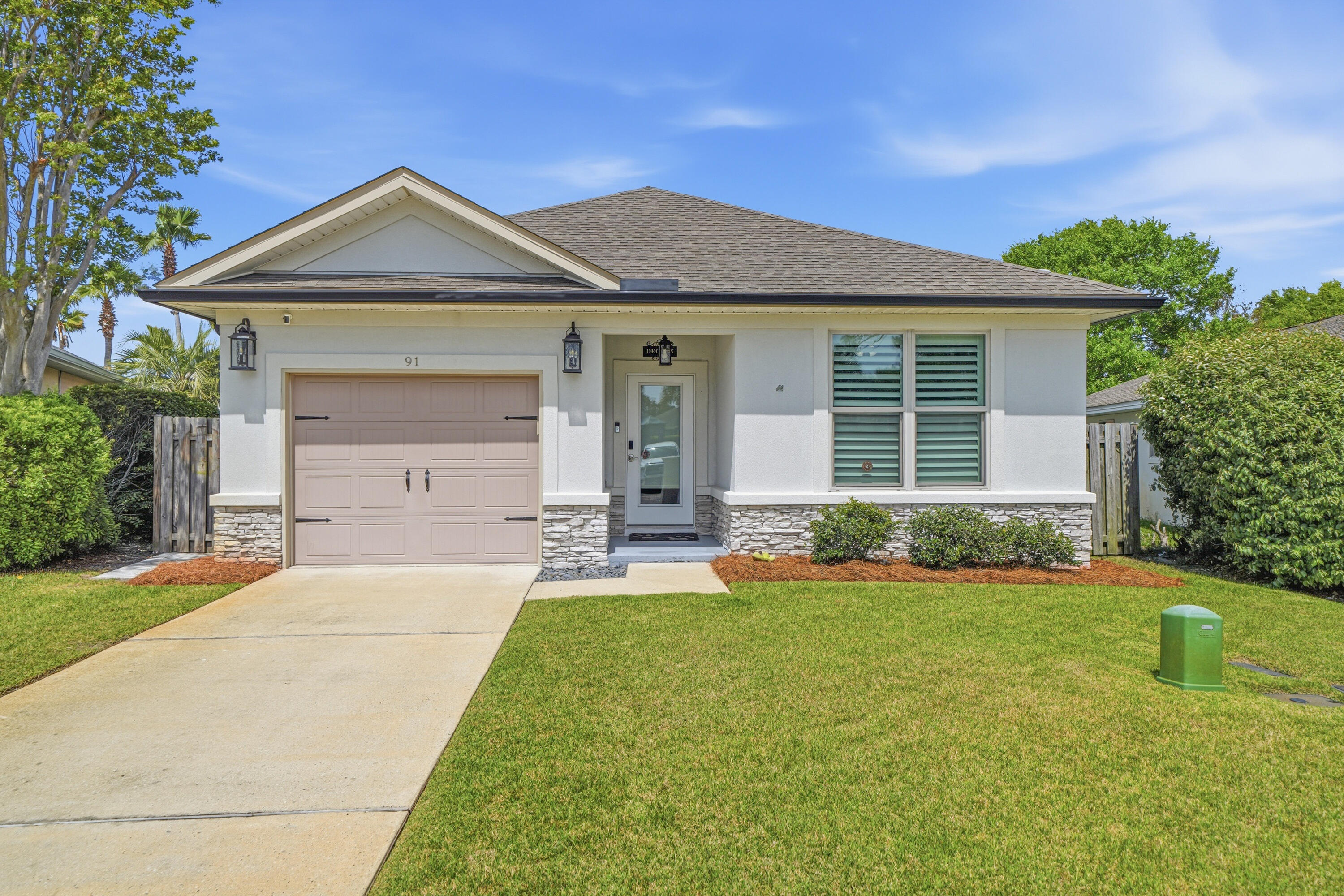 Presenting 91 Bayside Park: a beautifully maintained, custom-built home completed in 2017 and offering the feel of near-new construction. This move-in ready property is perfectly positioned directly across from the community park, featuring a resort-style pool, tennis and pickleball courts, playground, pavilion, expansive green space, and a 100-foot dock extending into the bay for residents to enjoy.  Since completion, the owner has invested approximately 90k in upgrades, including epoxy flooring in the garage, plantation shutters throughout, a full gutter system, covered rear patio, brick paver enhancements, and upgraded attic insulation for improved energy efficiency, plus additional thoughtful improvements. This turnkey home offers both comfort and convenience in an unbeatable location.