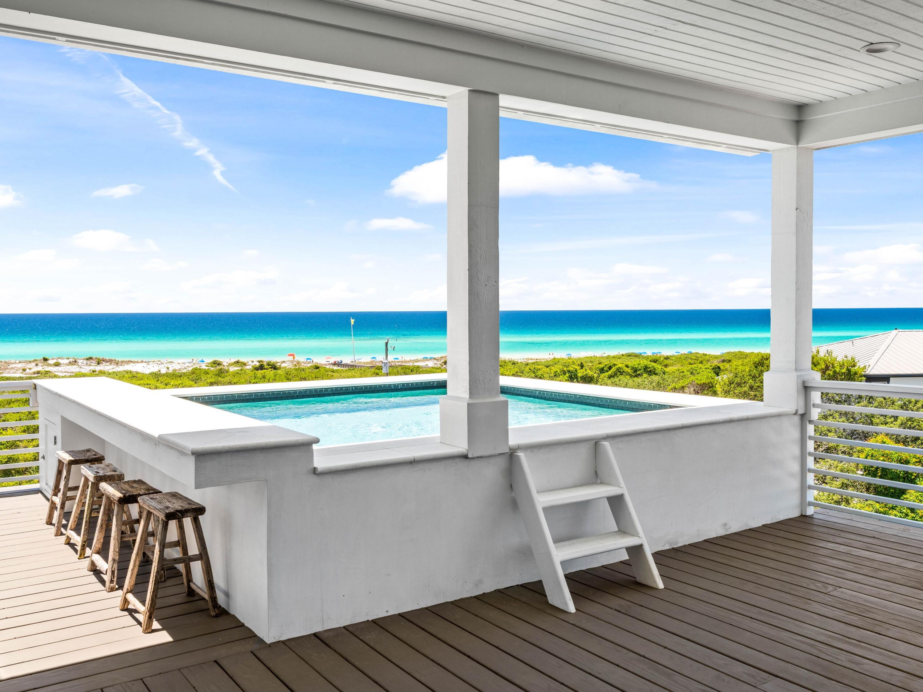 A rare opportunity just steps from the Gulf, this four-level custom home in the community of Mala Beach represents a standard of construction with features rarely seen on the Emerald Coast. Built as a personal home, every material and finish was hand curated -- and it is evident throughout the residence. Spanning an immaculate 6,018 square feet with an elevator servicing all levels, there are four spacious primary suites with king beds and  two bunk rooms.  The first floor sets the coastal tone with a large open living area with Peacock paver floors and floor-to-ceiling Jeldwen windows allowing in a multitude of light.  A dining area, marble wet bar with sink and refrigerator, powder bath, laundry and connected garage which is currently being used as a game room complete this level. The second floor hosts two of the four primary suites, both with an all-marble bathroom featuring a freestanding soaking tub, rain head shower, and floating vanities, along with private balcony access. Also on this level are the two generously sized bunk rooms, each sleeping five guests across three singles and one full sized lower bunk, and each with a dedicated bathroom with large walk-in shower. The third floor delivers two additional king primary suites, both with direct balcony access and Gulf views. The bathrooms are equally impressive with freestanding tubs, oversized marble showers with ceiling-mounted rain heads, and dual floating vanities with Carrara marble countertops. Every bedroom in this home has been finished with the same uncompromising attention to detail; the only difficult decision will be choosing which one to claim. The fourth floor is the crown jewel of the home. A dramatic vaulted ceiling opens over a fully integrated living, dining, and kitchen space. The chef's kitchen anchors the room with a handcrafted La Cornue range that draws attention the moment you walk in, a paneled SubZero refrigerator, Italian-made cabinetry and honed Carrara marble countertops. The powder room on this level is finished in hand-made Moroccan Zellige tile. Euro Wall sliding doors open the entire living space to the magnificent rooftop deck complete with heated pool. In total, the home offers over 1,000 square feet of outdoor living space across all levels. Designed to embrace its stunning surroundings, the floor plan seamlessly flows from indoor to outdoor spaces, offering views of the majestic Gulf waters and the picturesque white beaches. This remarkable retreat is a must-see for the discerning buyer seeking the ultimate blend of serenity, style, and coastal charm. Mala Beach is a seven-home Gulf-front community in Inlet Beach, just steps from one of Walton County's best beach accesses and minutes from Alys Beach, Rosemary Beach, 30Avenue and all of the shopping and dining venues.