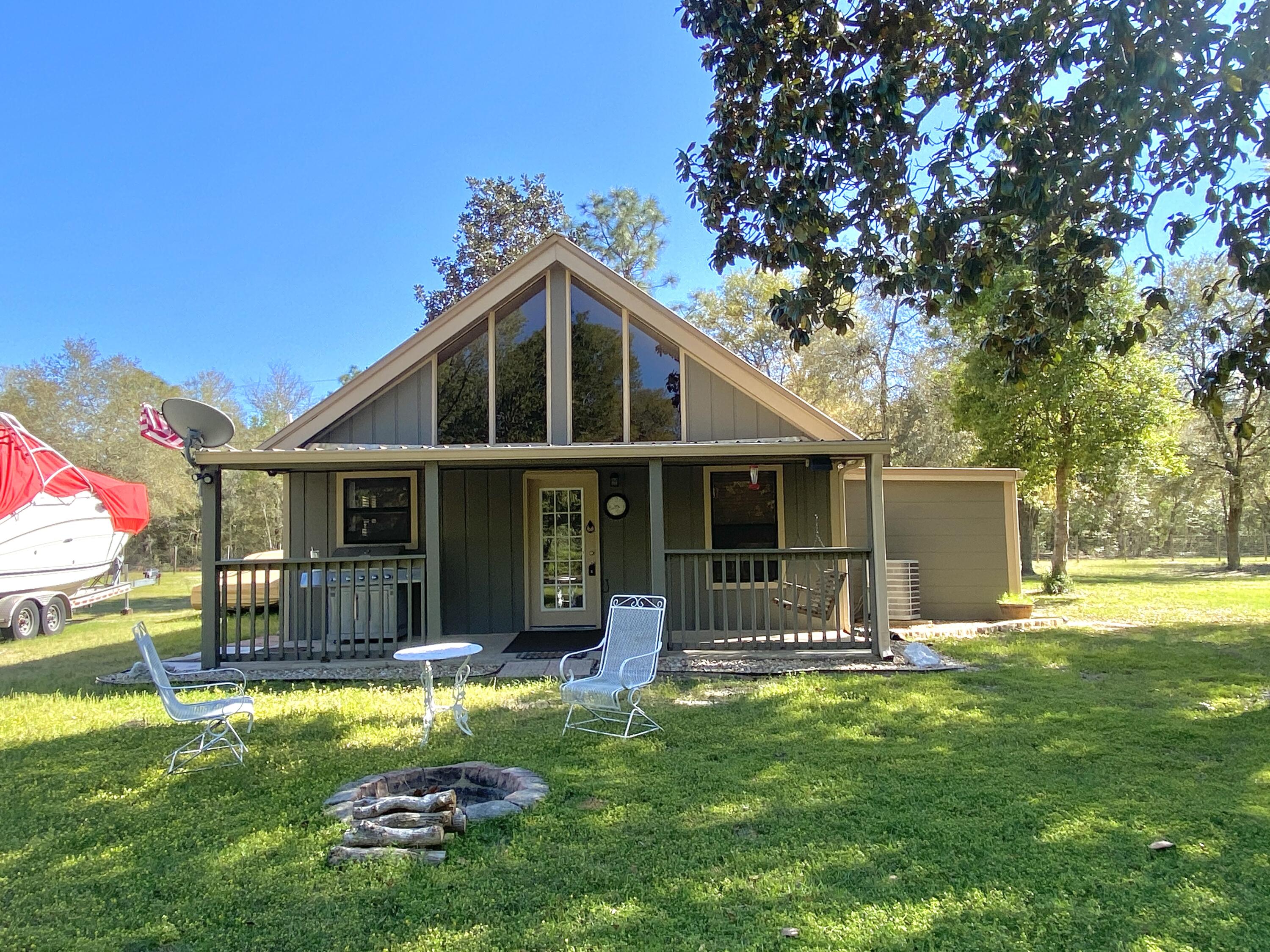 Available May 7th, 2026. Country living and privacy in Crestview This 3/2 features a sunroom as well as loft FLEX space upstairs.  Wooded privacy on just over 4-acres w/ covered front porch, perfect for rocking chairs or relaxing with a cup of coffee.  Spacious living room, vaulted ceilings, rustic kitchen cabinets and beam accents.  Spacious bedrooms with country accents.  AS IS Outdoor lean-to, yard building with fenced area.  No inside smoking or vaping. Pets will be allowed with owner approval. Sorry no cats due to allergies.  Gated entry on property.  This is a must see for affordable country living and privacy. Applications can be made at www.rentgoodlife.com. Non-refundable fees apply. AS IS tractor