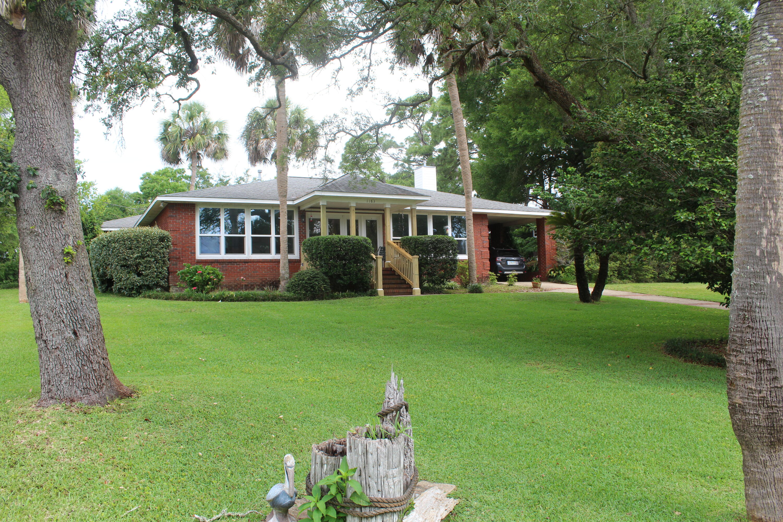 Move-in ready and lovingly maintained, this beautiful all-brick corner lot home offers over 2,000 square feet of comfortable living space with waterviews and exceptional functionality throughout. Featuring 3 bedrooms and 2 bathrooms, this home is filled with natural light thanks to hurricane-impact windows & thoughtfully designed living spaces. The spacious floor plan includes a cozy gas log fireplace, large pantry & generous living and dining areas ideal for everyday living and entertaining. Enjoy peace of mind with a brand-new roof, whole-house generator, updated hurricane windows & irrigation system already in place. Outdoor living shines with an updated front porch, screened back porch, patio/garden area, and plenty of parking for guests, boats, or additional vehicles. A large storage/workshop space provides endless possibilities for hobbies, projects, or extra storage needs. The BIG BONUS for this property is the empty lot attached that can be sub-divided for another home or used as a recreational area for the owner, pets and/or numerous other possibilities! This well-cared-for property combines comfort, durability, and beautiful water views in a truly move-in-ready package. Professional Photos to Come!