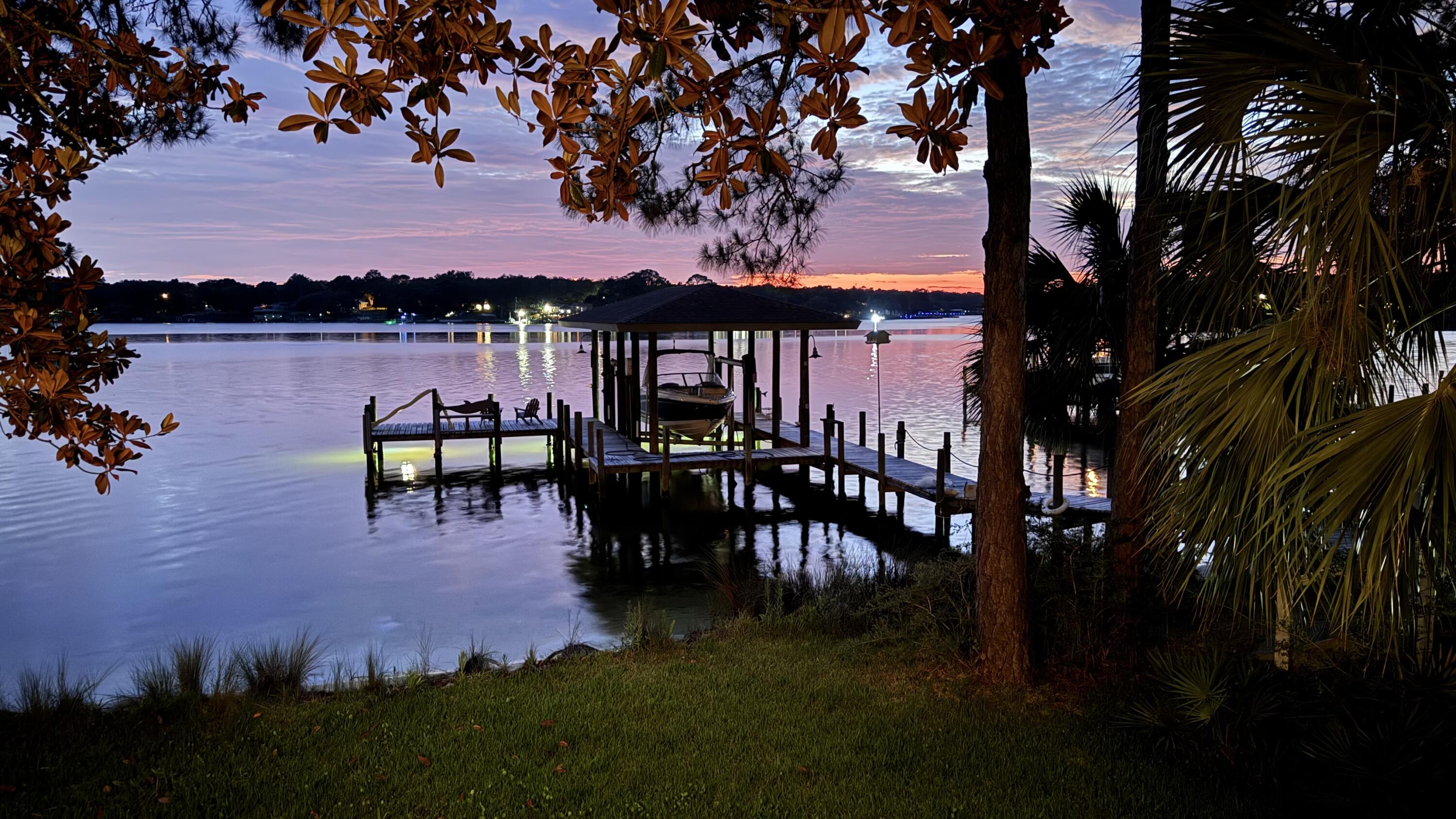 Positioned on a private one-acre homesite with 130 feet of deep waterfront, this property offers a setting centered around the water. Set back from the street, the home enjoys a sense of privacy while maintaining expansive water views from the residence, deck, and dock. A large deck provides ample space for outdoor dining, entertaining, or simply taking in the sunset as it dances across the water. The private dock with boat lift offers direct access to the water, making boating and fishing part of everyday life. Inside, you will find an updated kitchen with a gas stove and plenty of storage.  This home offers privacy, a sense of home and room to expand as your family does.