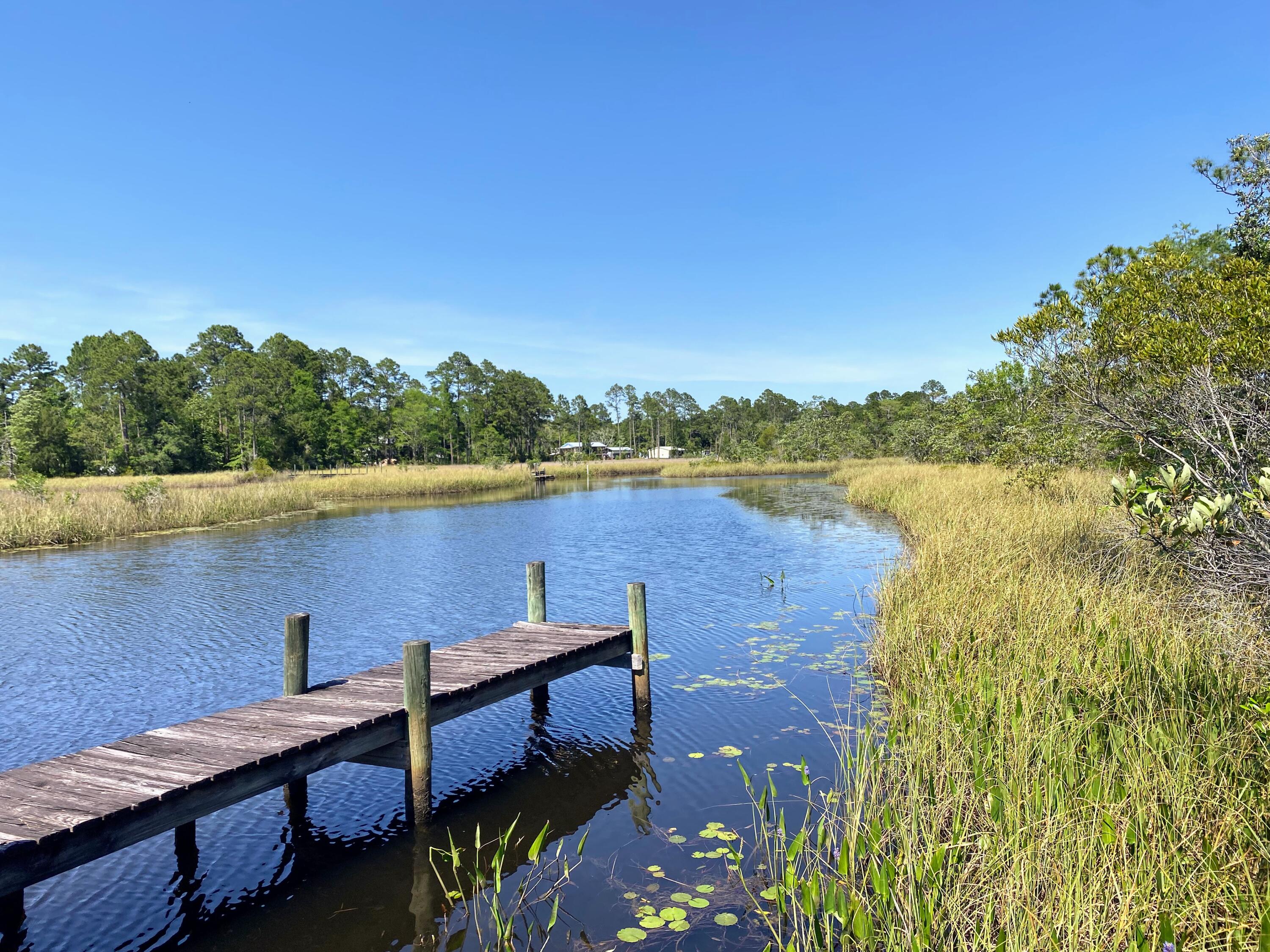 WATERFRONT. A rare opportunity to affordably own half of a large waterfront parcel with dedicated shared ownership and access to an existing private dock, offering immediate enjoyment of the waterfront lifestyle while you plan and build your dream home.

From your dock, explore Escambia Bay, the Blackwater River, the Gulf of Mexico, and even cruise by boat into historic downtown Milton. This peaceful waterfront setting offers the best of both worlds--an uncrowded, Old Florida atmosphere surrounded by nature, yet with exceptional convenience. Interstate 10 is less than five minutes away, providing an easy commute to Pensacola, while the property's location on the east side of Escambia Bay allows quick access to Navarre Beach without crossing the toll bridge.

The generous homesite features ample upland area for construction while the shoreline remains protected as a natural Florida marsh, ensuring your waterfront views and the property's unspoiled character are preserved for years to come. Unlike many waterfront conservation properties, this parcel includes shared ownership and use of an existing private dock, allowing you to enjoy boating, fishing, kayaking, and waterfront sunsets from day one.

Whether you're envisioning a private coastal estate, a weekend retreat, or your forever home, this property offers an exceptional combination of privacy, natural beauty, boating access, and convenience.

Survey, wetlands delineation, and dock access documentation are available.