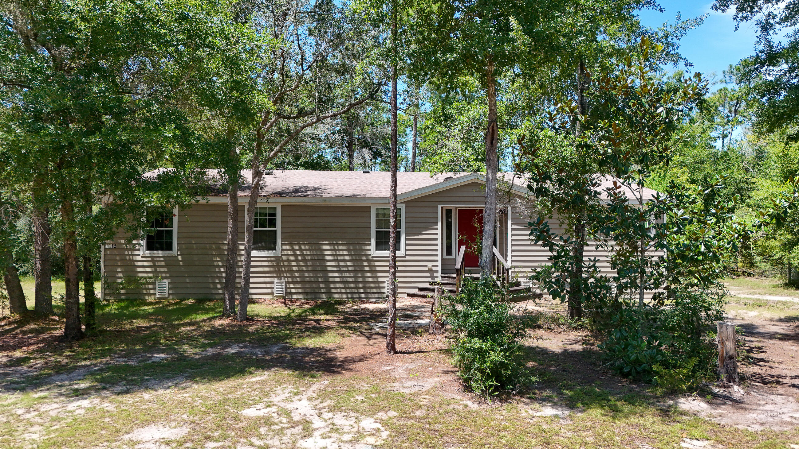 Great opportunity in a growing area A spacious 5-bedroom, 3-bath triple-wide mobile home featuring durable LVP flooring, crown moulding, and an open living area with a cozy fireplace. The large kitchen has an island, ample cabinetry, and generous counter space. Large windows fill the home with natural light. Surrounded by mature trees, the land offers both privacy and potential for many outcomes, whether you're looking to add multiple mobile homes, build new construction, or create a small subdivision. The location is wonderful, being just minutes from Deer Point Lake, Lynn Haven shopping and dining, and within 20 miles of the white sands of PCB, this property is ideal for investors or anyone looking for space, flexibility,