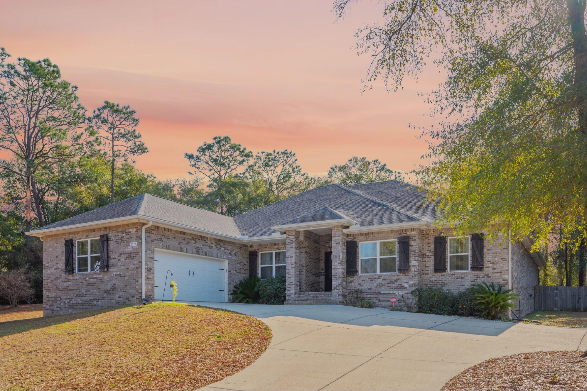 Welcome home to 5777 Wildwood Rd, a 3,121 sq ft luxury carriage-style residence where detail takes center stage. This 4-bedroom, 3-bath home showcases bamboo floors throughout, soaring 12-ft ceilings, custom beams, shiplap walls, brick accents, and a propane fireplace anchoring the family room. The gourmet kitchen features quartz countertops, a gas range, smart refrigerator, and large pantry, perfect for entertaining. Enjoy a game room, formal dining with tray ceilings and wainscoting, and a theater room with padded walls. The primary suite stuns with a barnwood accent wall, large closet, concrete safe room, and oversized 6x6 rain shower. Step outside to a covered patio and enclosed heated saltwater pool and hot tub on a private, fully fenced .85-acre lot.