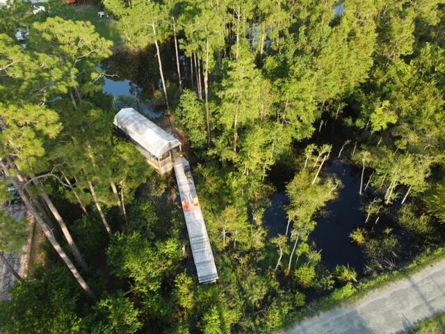 A unique residential homesite offering privacy, natural surroundings, and canal access toward the Choctawhatchee Bay. Although the property is currently referenced as N Eden Park Drive, it is physically located at the north end of Rendezvous Drive. The property features wetlands along the front, while the rear boundary meets a canal that narrows as it approaches the bay but remains accessible by kayak. The portion of the property containing the existing structure is located in Flood Zone X, creating an intriguing opportunity for a buyer with the vision to develop a private retreat.

An elevated walkway has already been constructed through the property, and permitting for the walkway and a proposed parking deck has been approved through FDEP and the U.S. Army Corps of Engineers. 

The property also includes a 12'x32' cabin structure with a main-level room, bathroom area, two lofts, tall ceilings, tongue-and-groove pine walls, and several partially completed electrical and plumbing components. The structure is a project and is being conveyed as-is, with no representation that it is currently permitted, habitable, or suitable for occupancy. This property is being marketed and sold as vacant land. The existing cabin is unfinished, has no utilities, and does not currently have the Walton County approvals or permitting necessary to obtain an official address or be represented as a permitted residence. Buyer is responsible for verifying all matters affecting the property, including permitting, addressing, utilities, wetlands, access, zoning, and development feasibility. Boundary survey, environmental/wetlands survey, and FDEP and U.S. Army Corps of Engineers permitting documents are available upon request.
