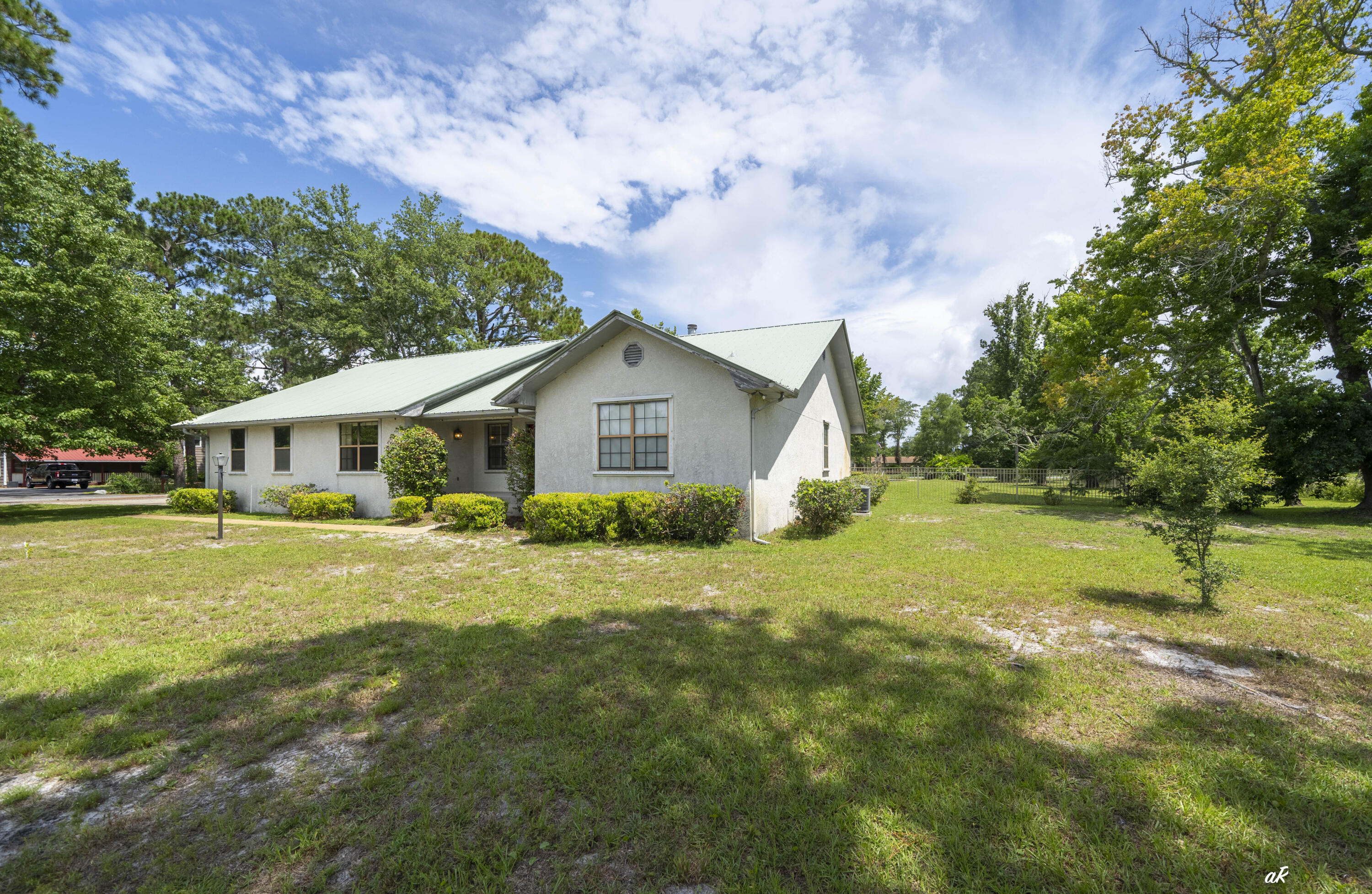 Rare opportunity to own 1.125 acres in Panama City Beach with no HOA. Located on a corner lot, this 4-bedroom, 2.5-bath home offers a split floor plan, 3-car garage, in-ground pool, hot tub, and a large screened porch designed for year-round outdoor living and entertaining. The living room is centered around a fieldstone natural gas powered fireplace and opens to the kitchen, which features a gas stove, pantry, water filtration system, and plenty of workspace. The primary suite offers direct access to the pool area, a large walk-in closet, and a private bath. On the opposite side of the home, the fourth bedroom provides flexibility for guests, a home office, or hobby space and includes private access to the screened lanai. Step outside to enjoy the nice sized pool, hot tub, and spacious outdoor living area. Whether hosting friends, grilling out, or simply enjoying the Florida weather, this space was built to be used. One of the property's most unique features is its three-sided street frontage, with Laird Street at the front, Jersey Court along the side, and Kingman Street at the rear. This uncommon layout provides excellent accessibility, added privacy, and future flexibility that is difficult to find in Panama City Beach. Conveniently located near shopping, restaurants, schools, and Naval Support Activity Panama City, this property offers the space and freedom of acreage living while remaining just minutes from the Gulf's white-sand beaches.