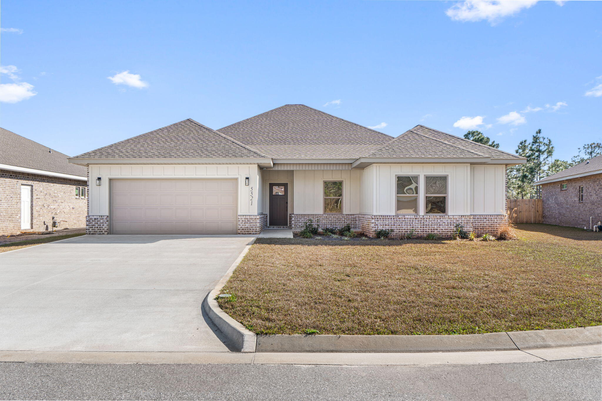 Affordable luxury can be yours!  Beautiful BRAND NEW 4 bedroom/2.5 bath modern craftsman style home in Gulf Breeze ready for occupancy now. Attractive brick & hardie-board exterior with covered front porch invites you inside to a wide open floor plan with high ceilings throughout & many upgraded features. Luxury vinyl plank flooring throughout the entire home - no carpet here! Spacious living room with custom built-in entertainment center opens right into the kitchen and dining area.  Gorgeous and thoughtfully designed kitchen features white shaker cabinets, sparkling Quartz countertops, tile backsplash, center island with breakfast bar, walk-in pantry, and stainless steel appliances including gas range and beverage cooler. Split-bedroom floor plan with 3 bedrooms at the front of the home, each with ceiling fans and lighted closets, plus a full bath.  At the rear of the home is the luxurious primary suite, with a spacious primary bedroom, en-suite bath with double vanity, freestanding bathtub, and huge walk-in shower, and a walk-in closet which connects to the laundry room.  Convenient half bath just off the living areas also has access to the covered back porch. Plenty of space for outdoor living with spacious covered back porch and fully-fenced backyard. All this, just 1 mile to Woodlawn Beach boat launch & new Soundside High School!