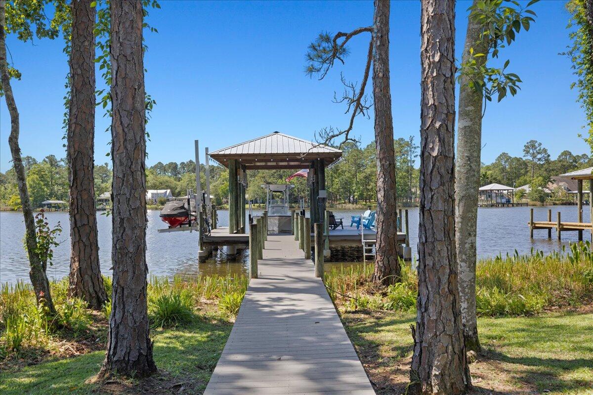 This coastal custom home is set on a protected bayou with serene water views. Enjoy your private dock which has $36k of upgrades that include a lift for a boat and 2 jet skis. The apartment above the garage offers versatility for an Airbnb or office. Enjoy Southern charm with brick pavers throughout, high ceilings, deep covered porches, including a 24x16 rear porch, and a fenced backyard with a small citrus grove. As a bonus, a 24kw whole-home generator supports both structures and the dock with 2 owned propane tanks. The main home offers 3bed/3.5 baths and a downstairs primary suite with a modern closet, soaking tub, and separate shower. The kitchen showcases an oversized island, gas range and extra storage in the kitchen galley. No HOA & room for a pool! Don't miss out A beautifully pavered driveway leads to the 2-car garage with a apartment above--complete with private bedroom, living area, bathroom, and kitchenette, ideal for rental income, guest suite, or office.

Located within easy reach of 30A, Blue Mountain Beach, and Grayton Beach, easy boating to North Beach and The Bay restaurants or head to Crab Island in Destin--perfect as a primary residence, second home, or investment opportunity.